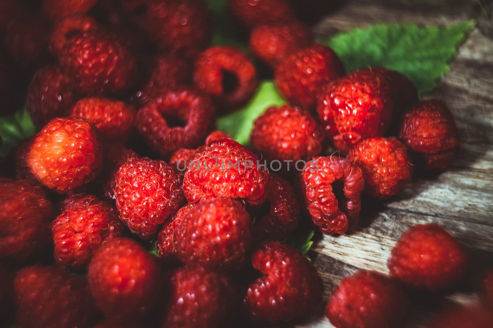 Macro photo raspberry berry. Texture background ripe pink raspberry berry. Fresh raspberries on a rustic wooden table. Selective focus. Bokeh.