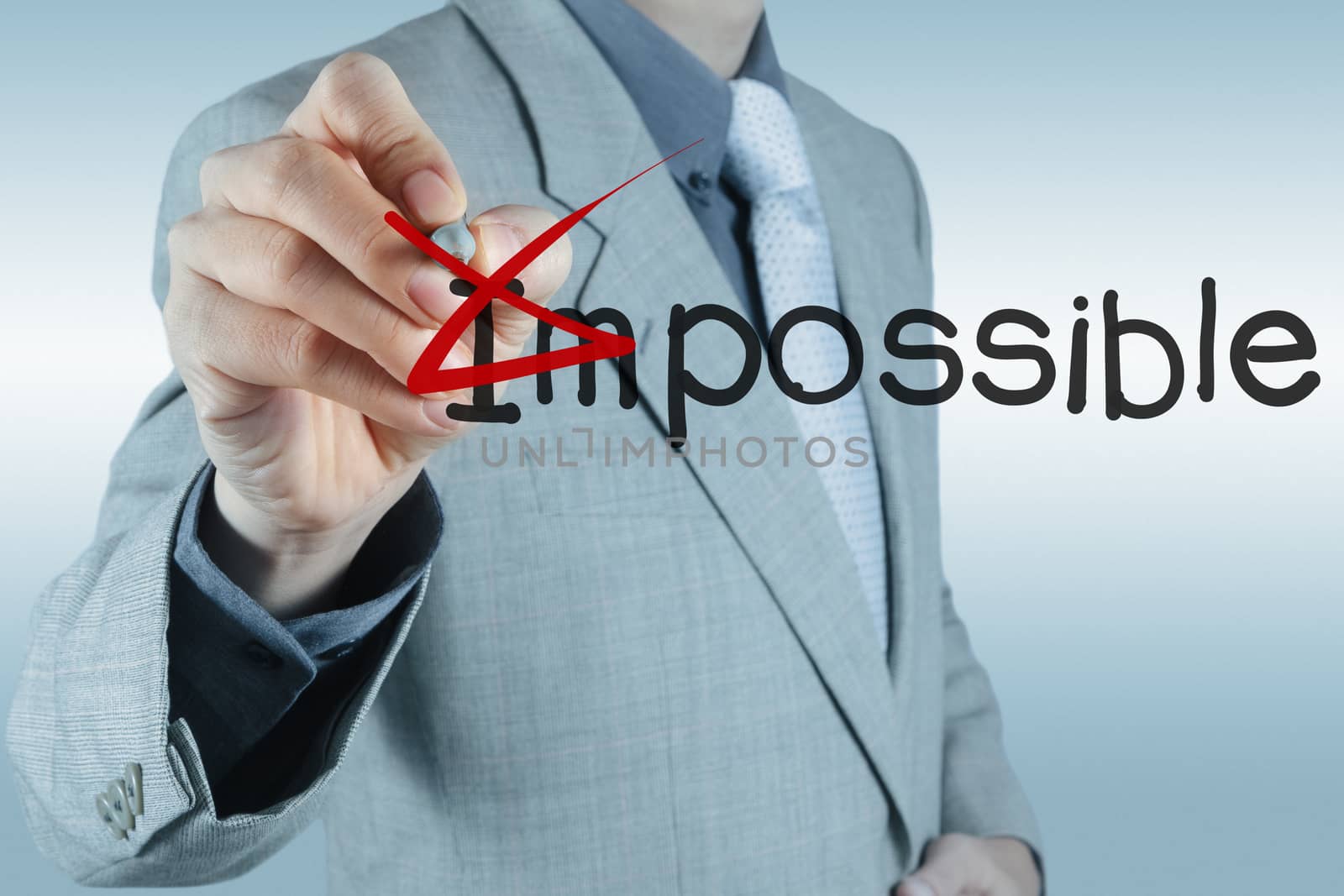 Businessman changing the word impossible into possible by everythingpossible