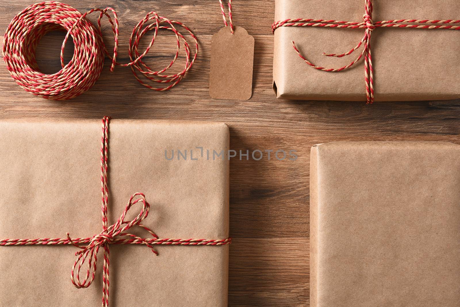 Christmas presents wrapped with eco friendly and recyclable paper and cord. High angle closeup in horizontal format.