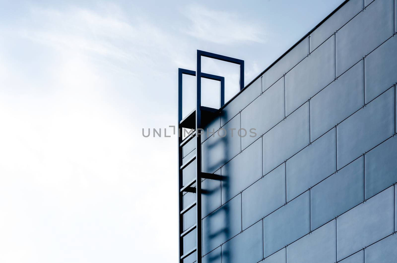 staircase to the sky and the wall of a modern building on a background of blue sky and clouds abstract background