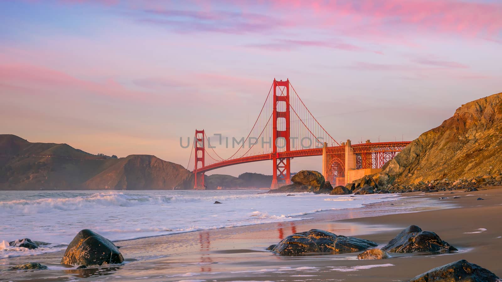 Famous Golden Gate Bridge seen from Baker Beach in beautiful golden evening light, San Francisco, USA