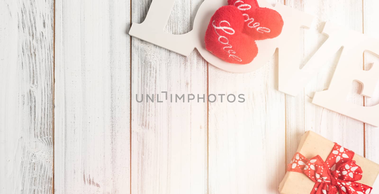 Love text,gift box and heart symbol on white wooden background