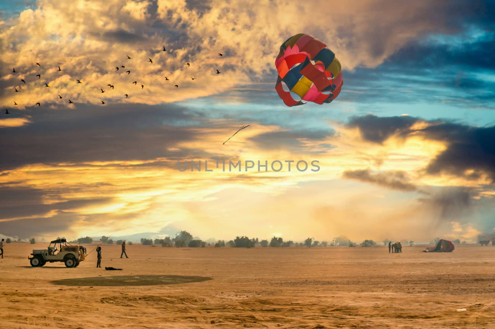 Jeep towing a parachute for adventure para gliding in the empty barren thar desert in rajasthan near jaisalmer and sum by Shalinimathur