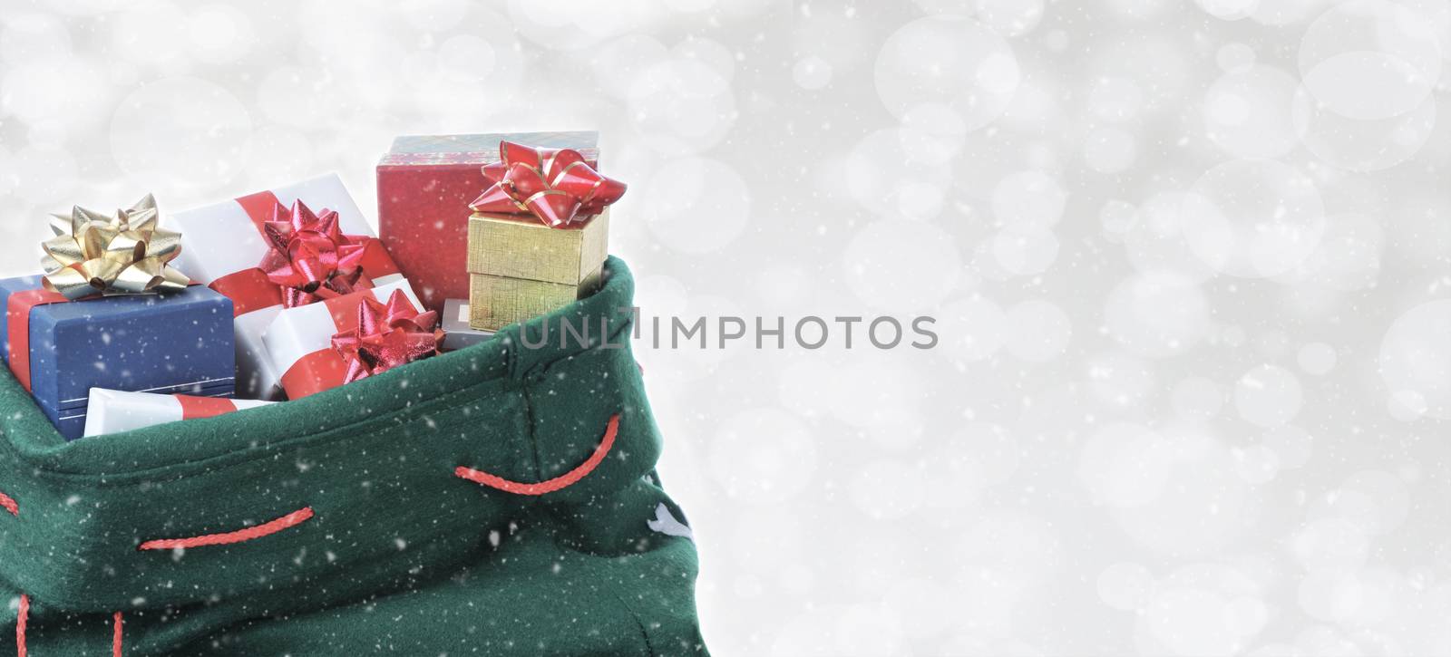 Santa Claus toy bag on a silver bokeh background with snow effect. Room For Copy.