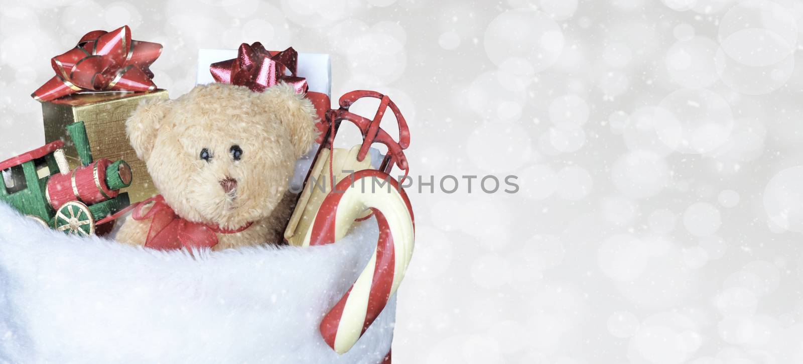 Christmas Stocking filled with toys - Banner size copy space. Bokeh Background with snow effect.