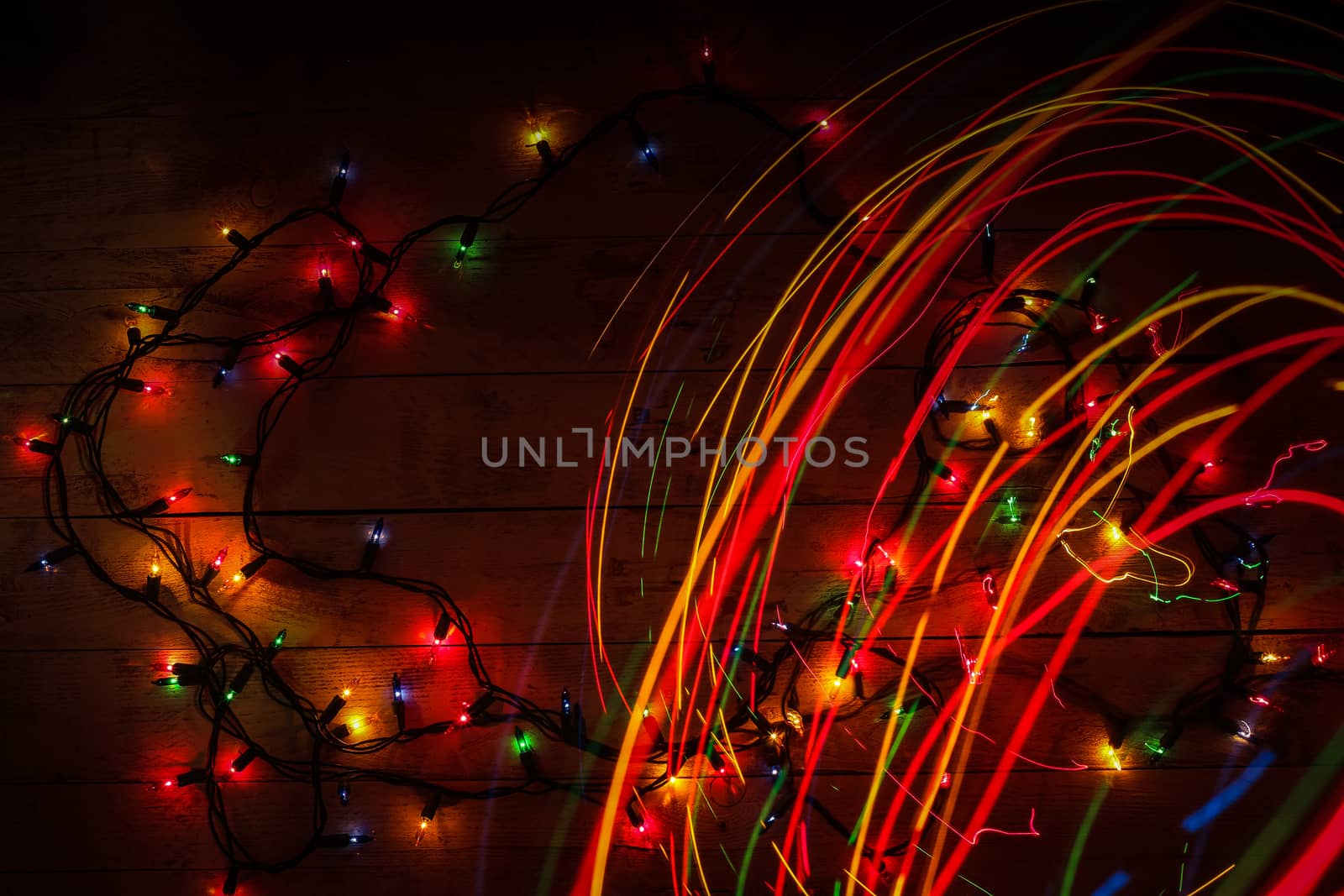 Colorful glowing garland on wooden background. Multicolored ligh by BarisevRoman