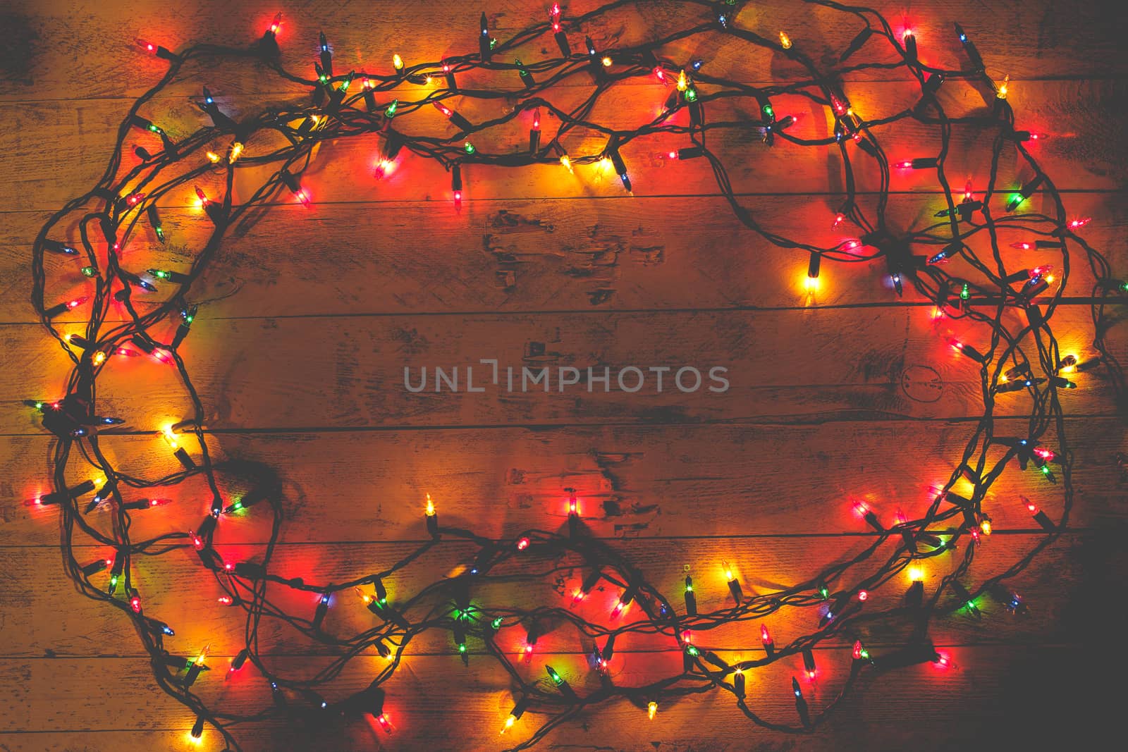 Christmas rustic background - vintage planked wood with lights and copy space. Garland. Tinted photo. Flat lay, top view. 