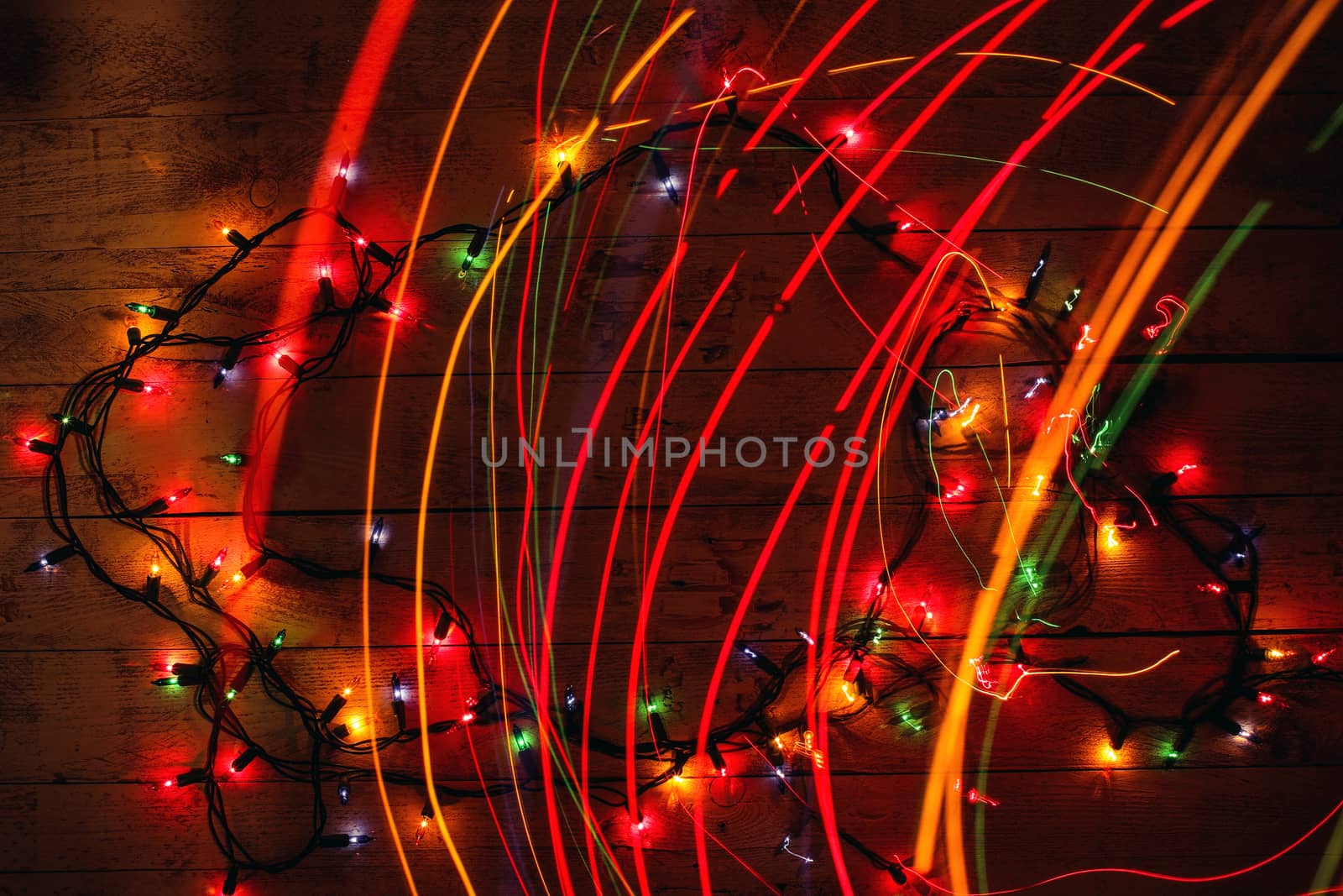 Glowing colorful Christmas lights on wooden background. by BarisevRoman