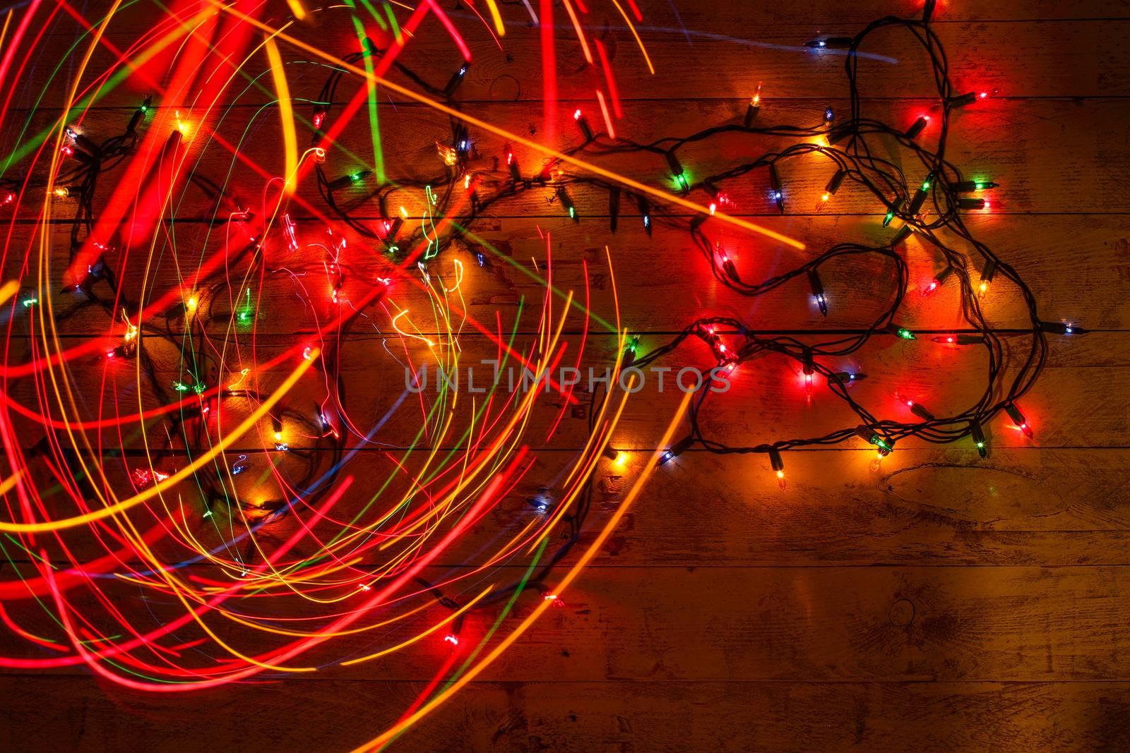 Colorful glowing garland on wooden background. Multicolored ligh by BarisevRoman