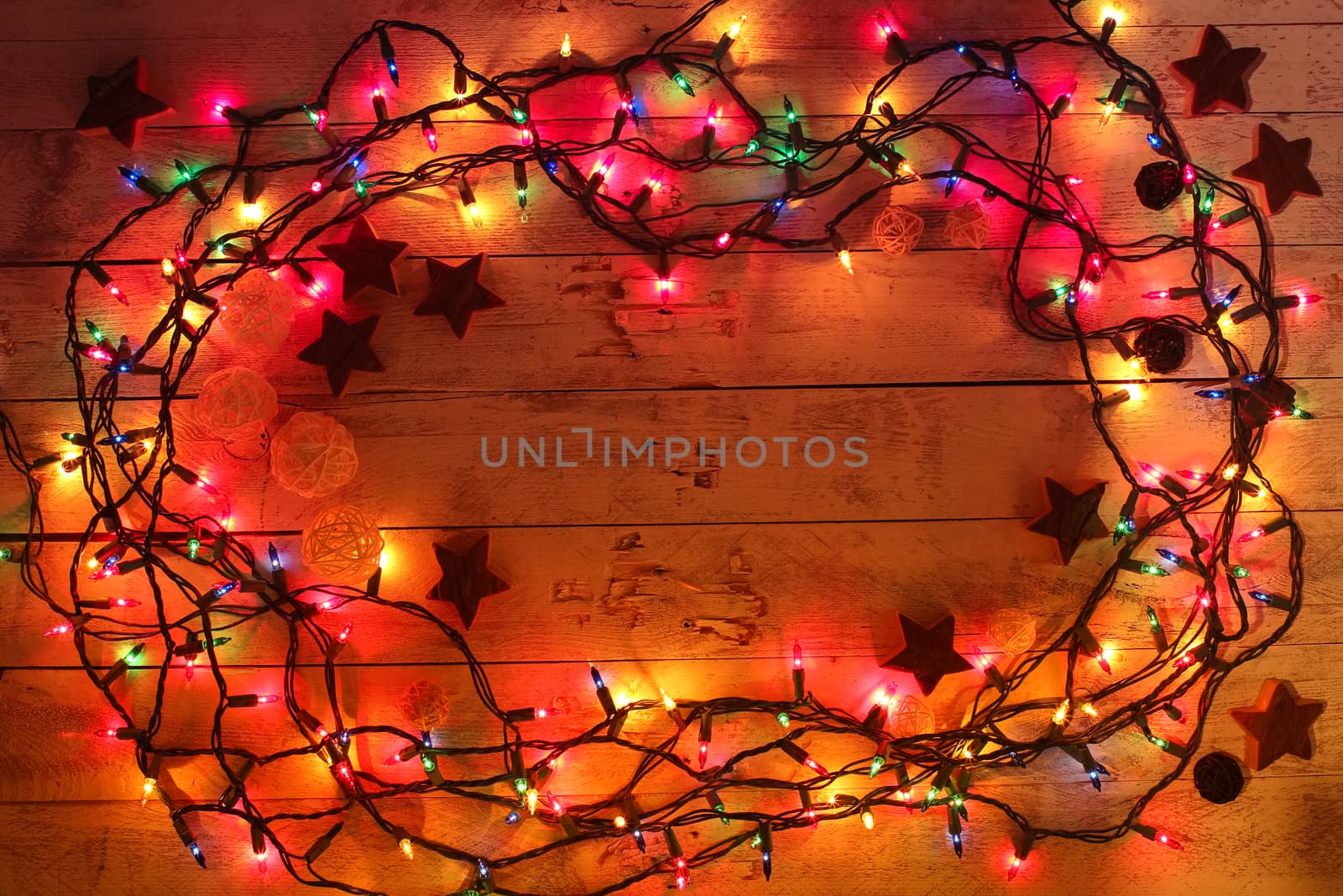 Glowing colorful Christmas lights on wooden background. Christmas wooden decor. Garland. New Year. Flat lay, top view, copy space. 