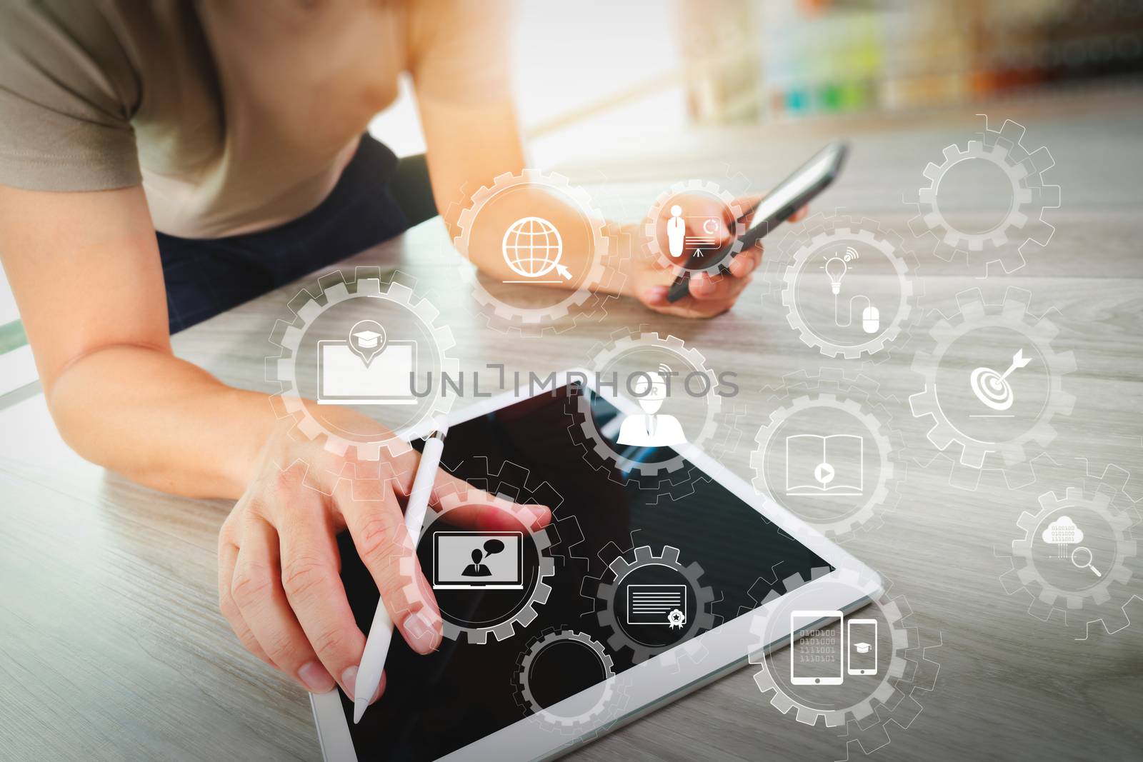 E-learning with connected gear cogs connected diagram virtual dashboard.top view of Designer hand working with digital tablet computer and smart phone on wooden desk as responsive web design concept