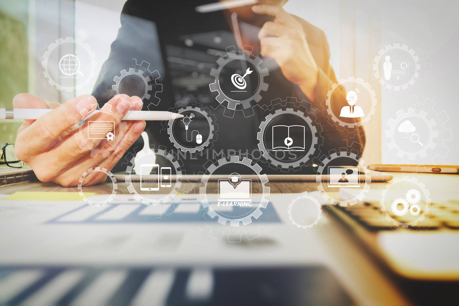 E-learning with connected gear cogs connected diagram virtual dashboard.business documents on office table with digital tablet computer with smart phone and graph business diagram and man working in the background