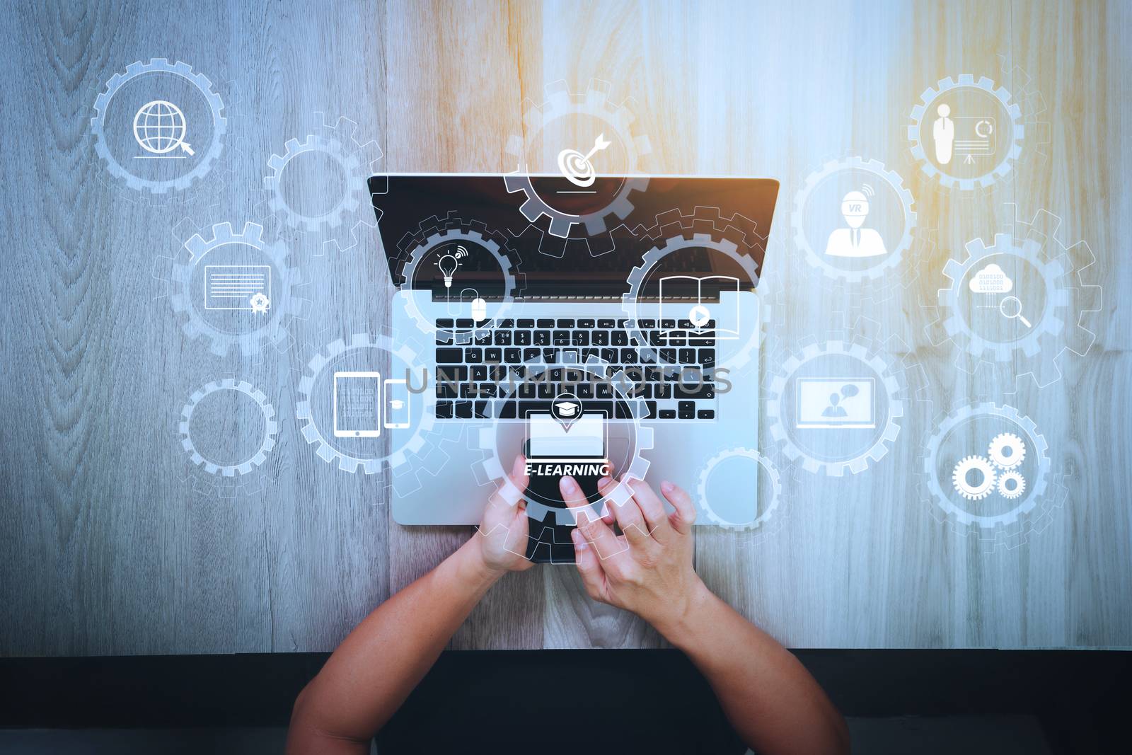 E-learning with connected gear cogs connected diagram virtual dashboard.top view of Designer hand working with smart phone and laptop computer on wooden desk as responsive web design concept