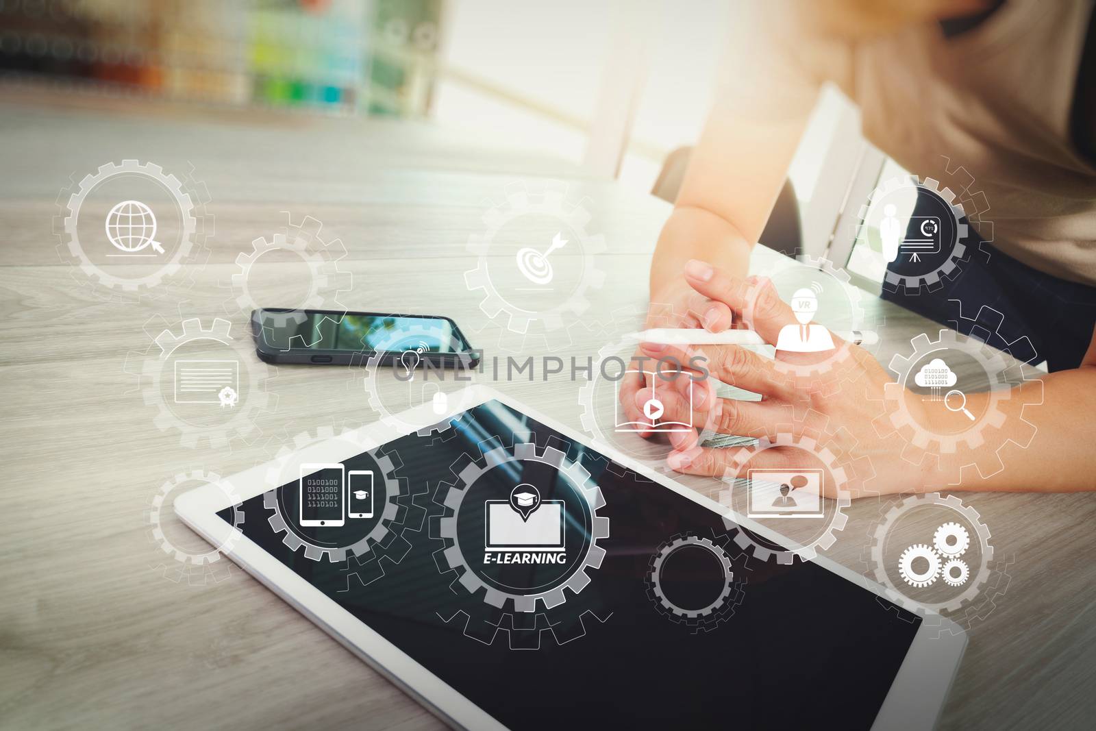 E-learning with connected gear cogs connected diagram virtual dashboard.top view of Designer hand working with digital tablet computer and smart phone on wooden desk as responsive web design concept