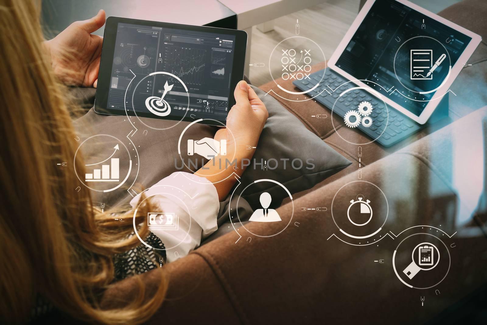 brunette woman using digital talet and laptop computer on sofa i by everythingpossible