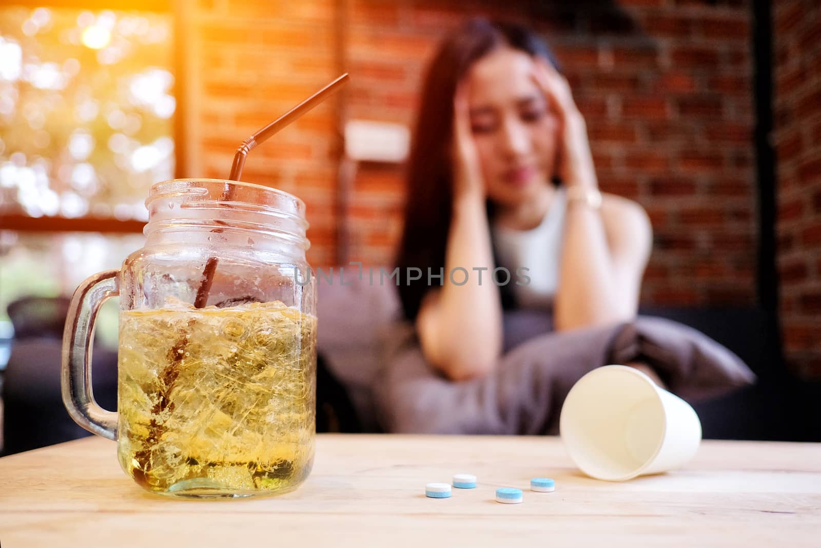 Beautiful woman in depression, drinking alcohol in The cafe by Surasak