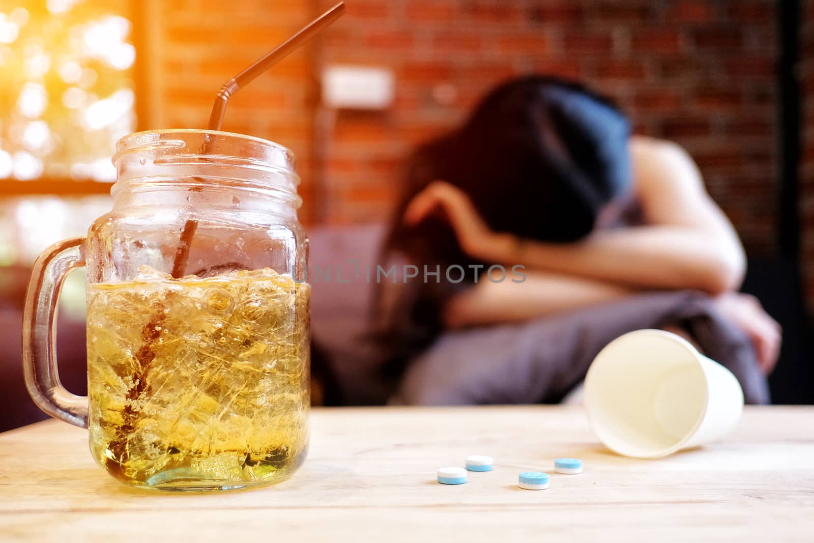 Beautiful woman in depression, drinking alcohol in The cafe by Surasak