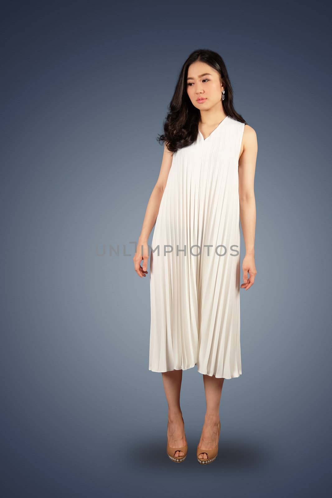 Young asian woman in white dress looking at the space for text on white isolate with clipping path