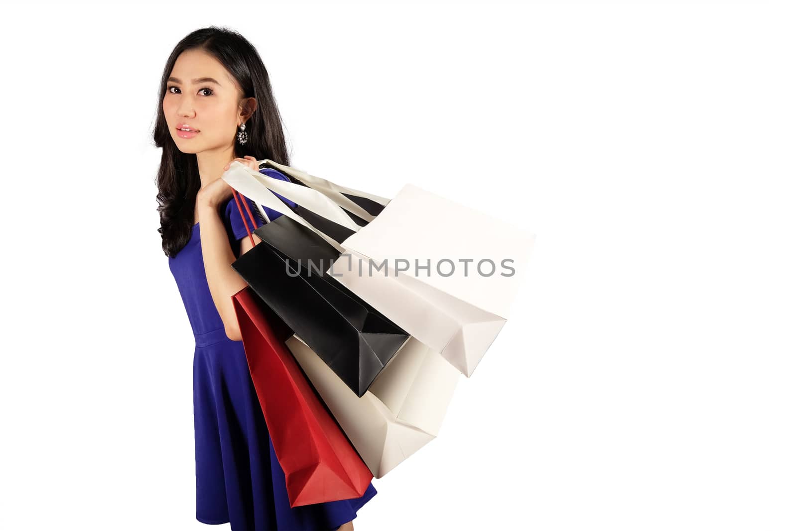 Happy women in blue dress with a shopping bag on white background and clipping path
