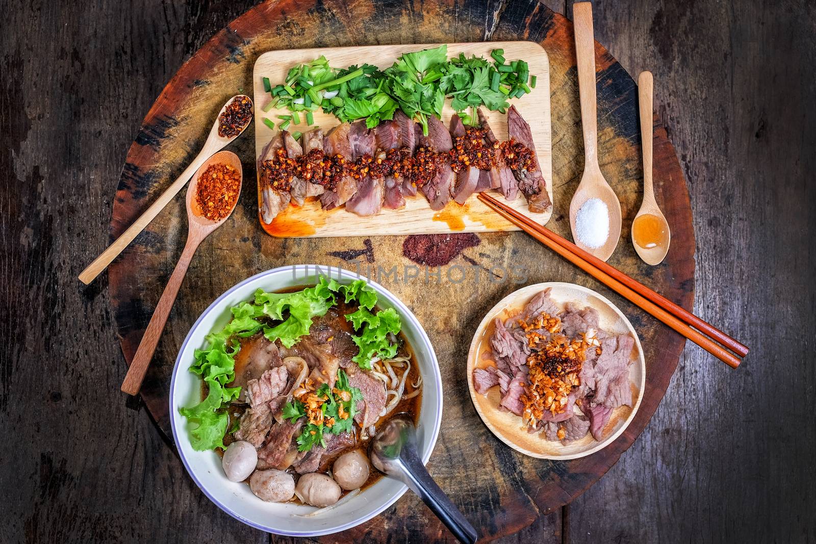 Thai food Noodle soup with beef on wood background by Surasak