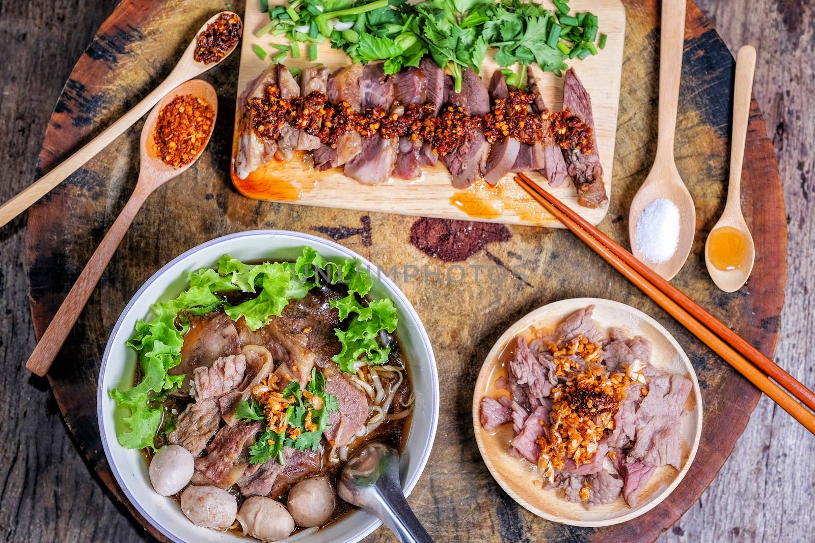 Thai food Noodle soup with beef on wood background by Surasak