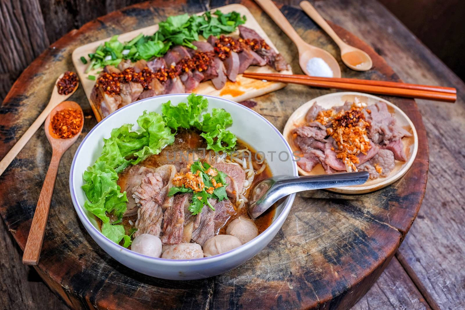 Thai food Noodle soup with beef on wood background by Surasak