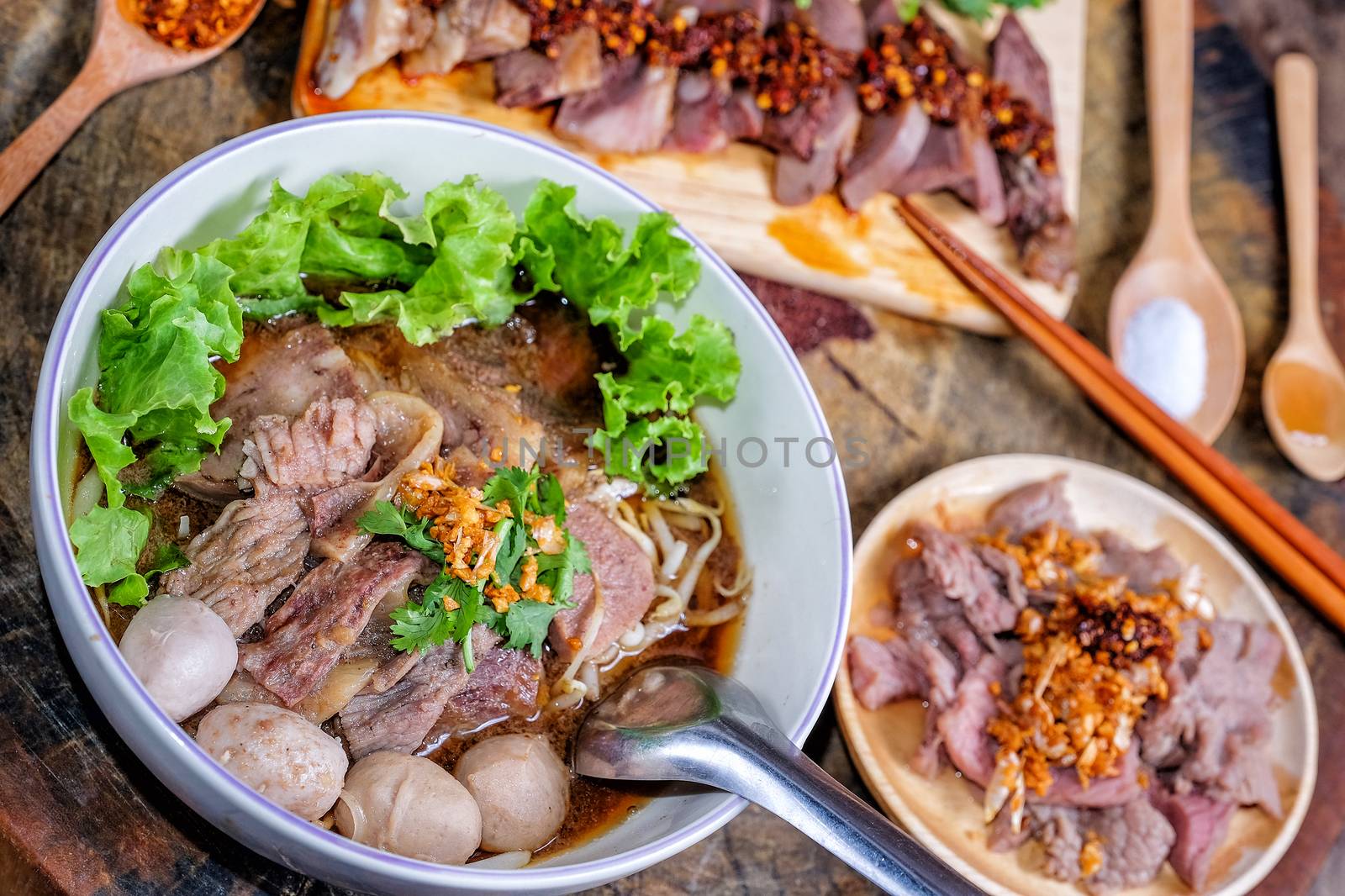 Thai food Noodle soup with beef on wood background by Surasak