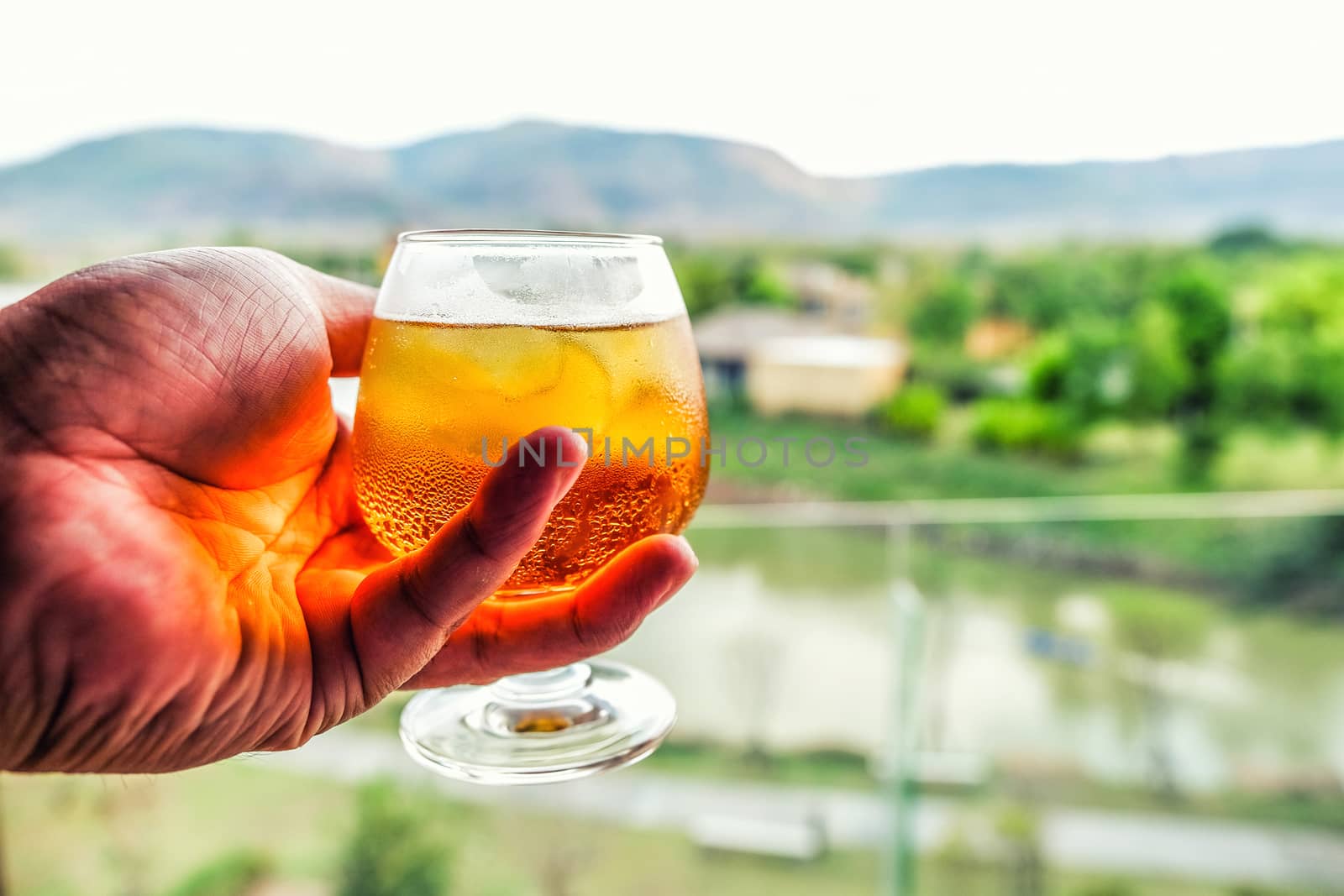 Glass of light beer in Hand by Surasak