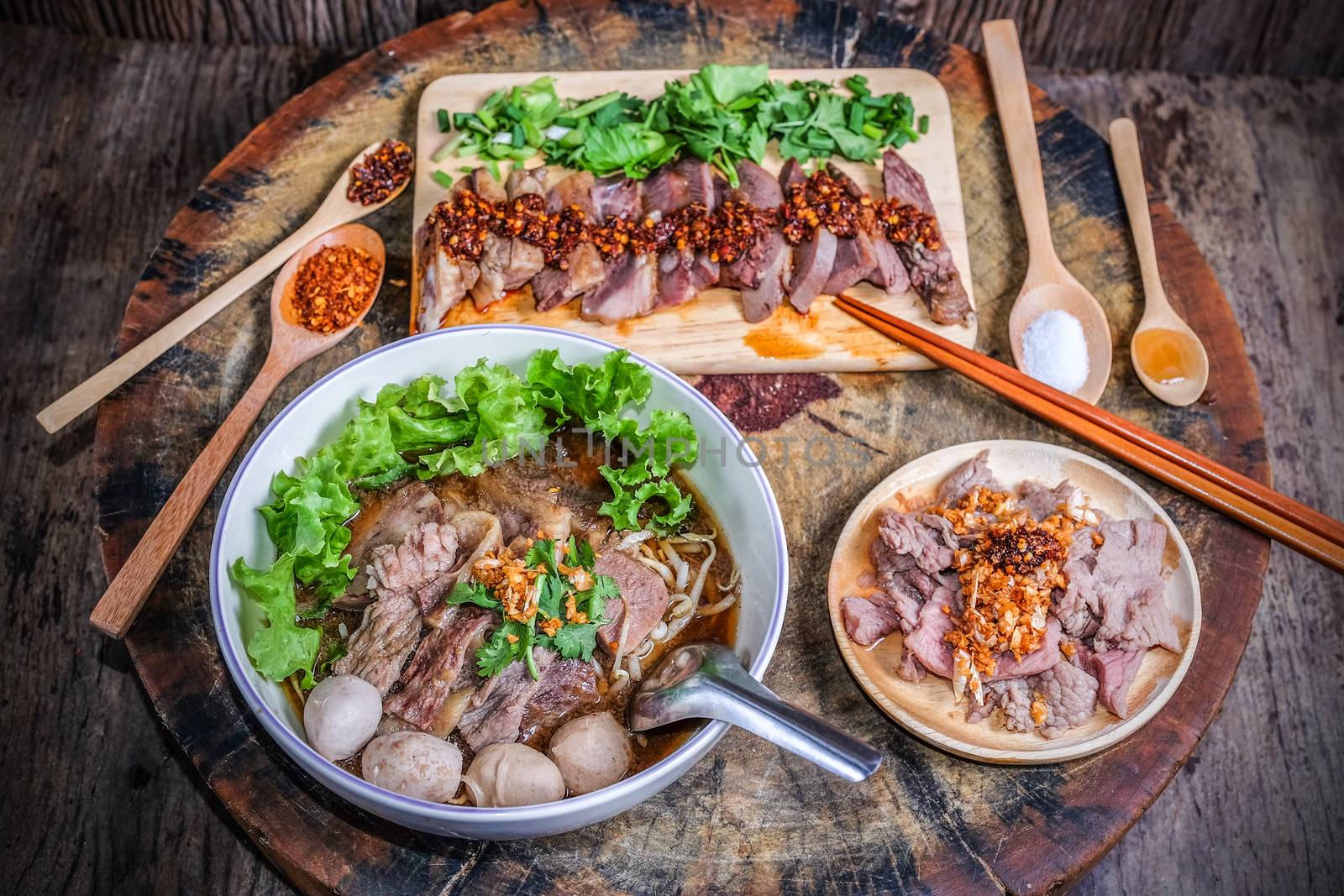 Thai food Noodle soup with beef on wood background by Surasak