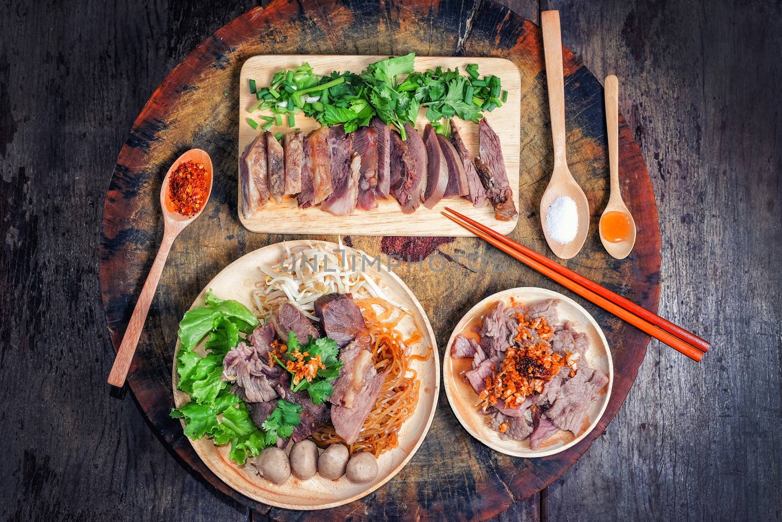 Thai food Noodle soup with beef on wood background by Surasak