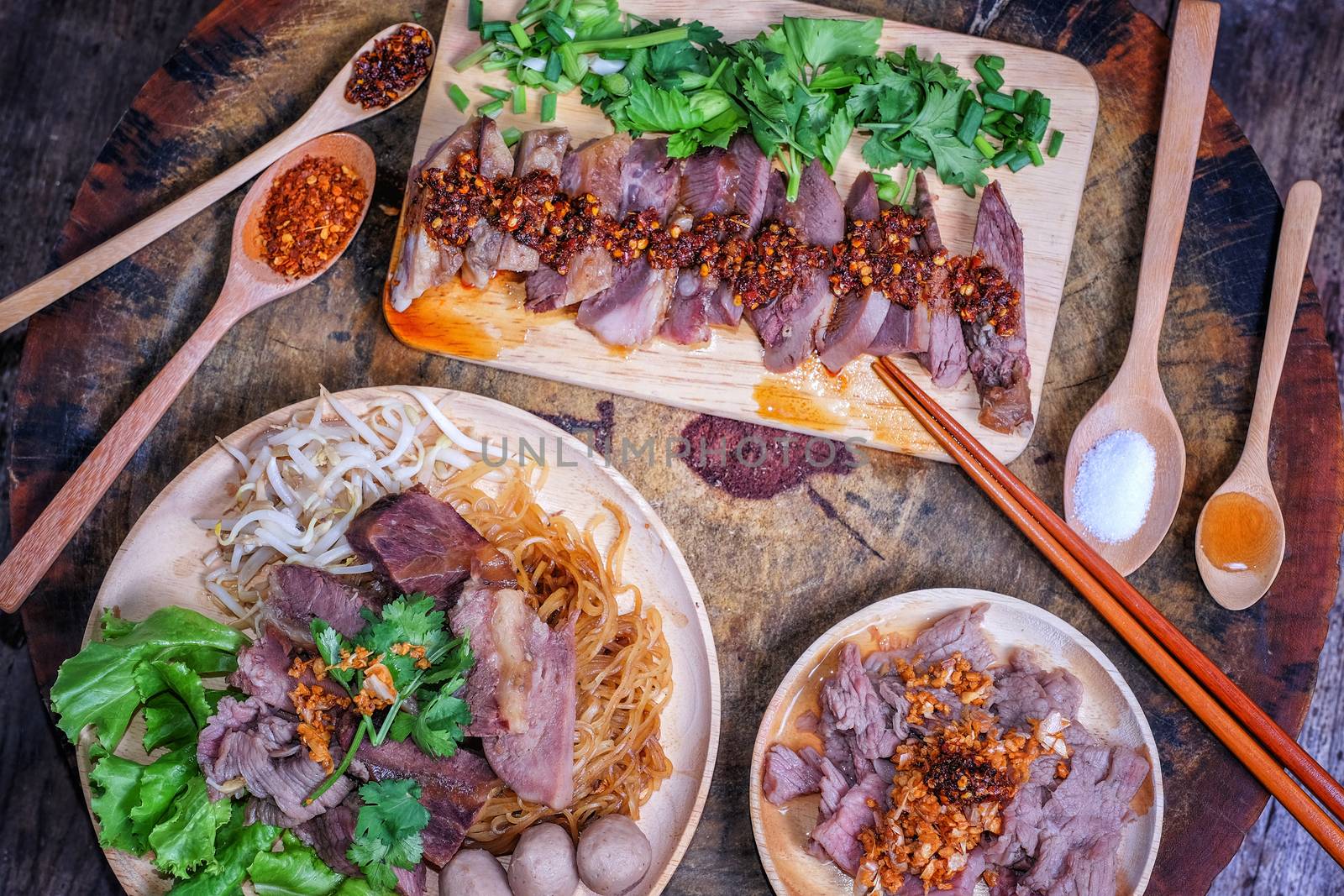 Thai food Noodle soup with beef on wood background by Surasak