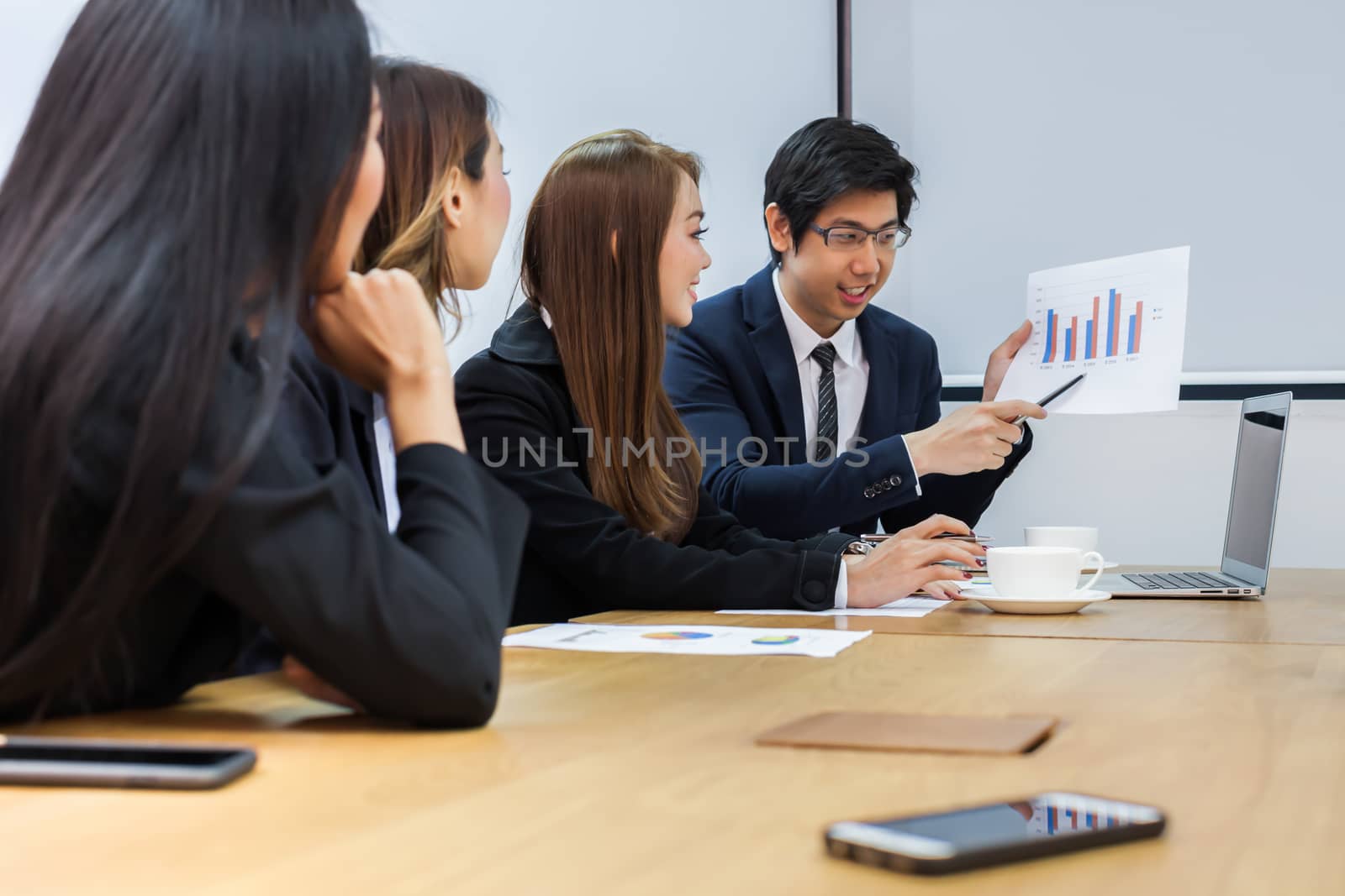 Asian business people make a group discussion in meeting room with document and computer putting on wooden table