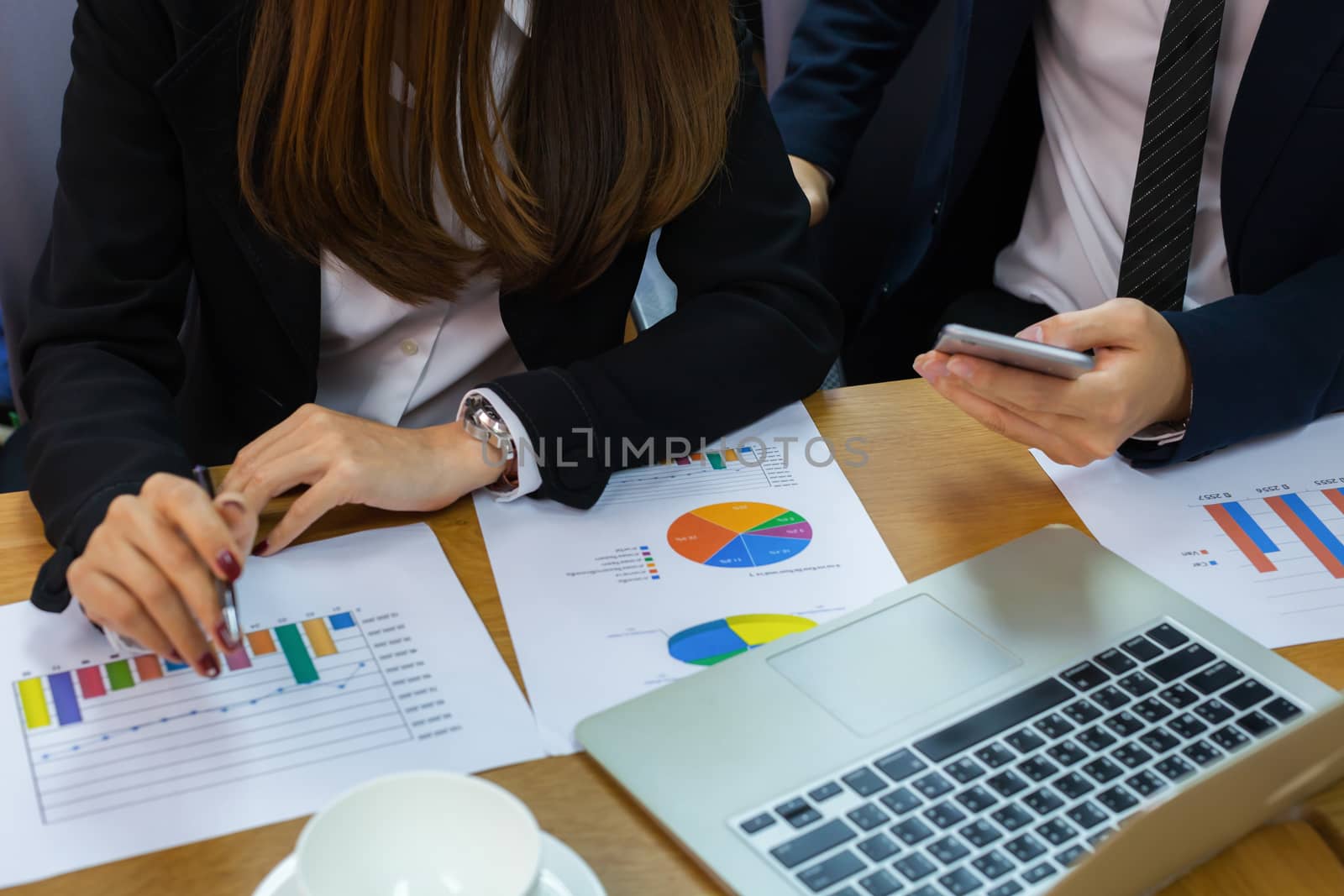 A business group discussion in meeting room with document and computer put on wooden table.