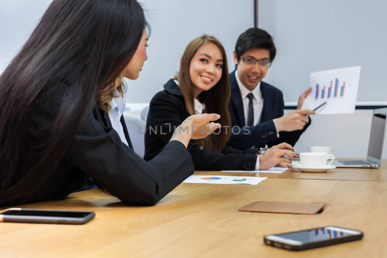 Asian business people make a group discussion in meeting room with document and computer putting on wooden table