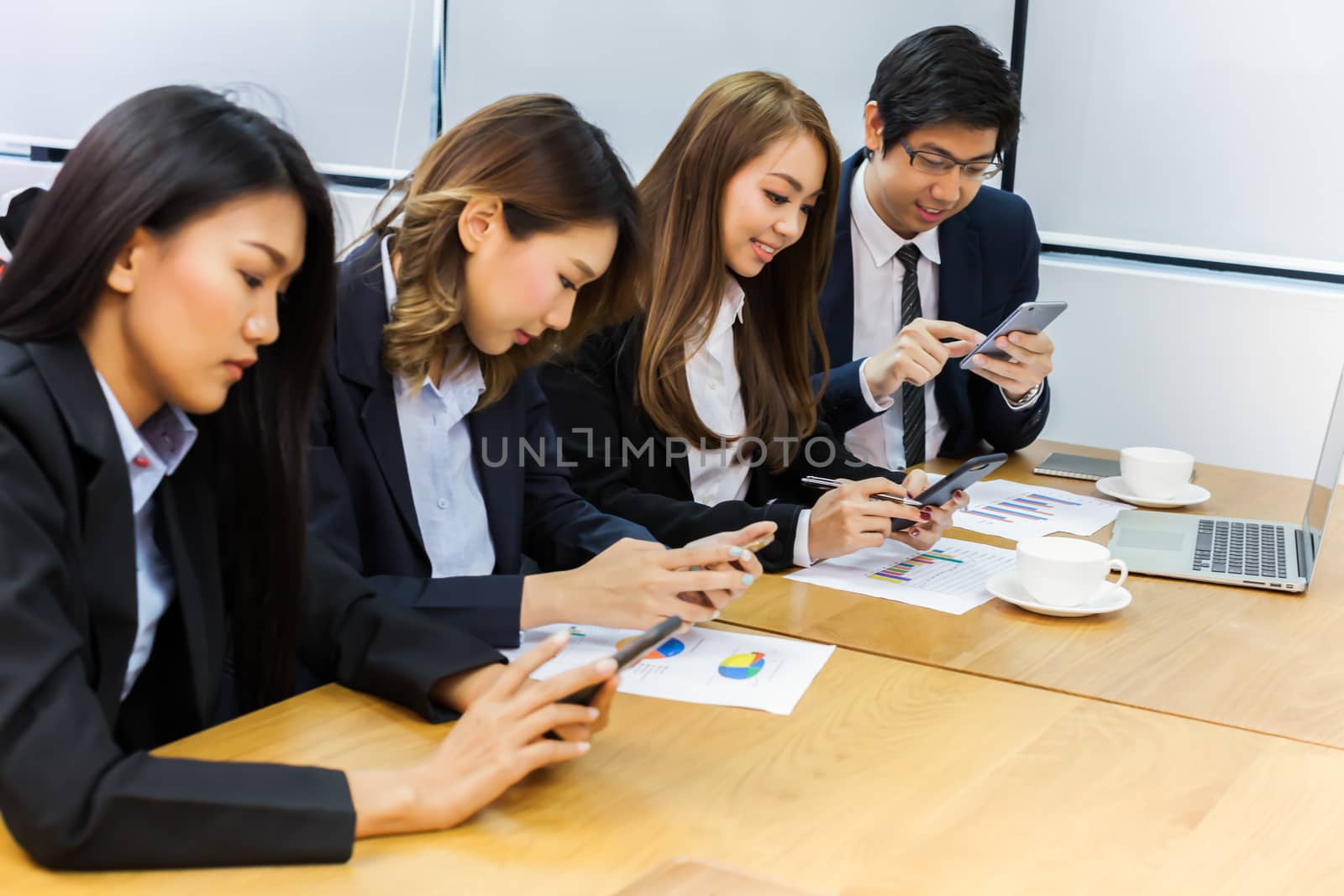 Asian business people make a group discussion in meeting room with document and computer putting on wooden table