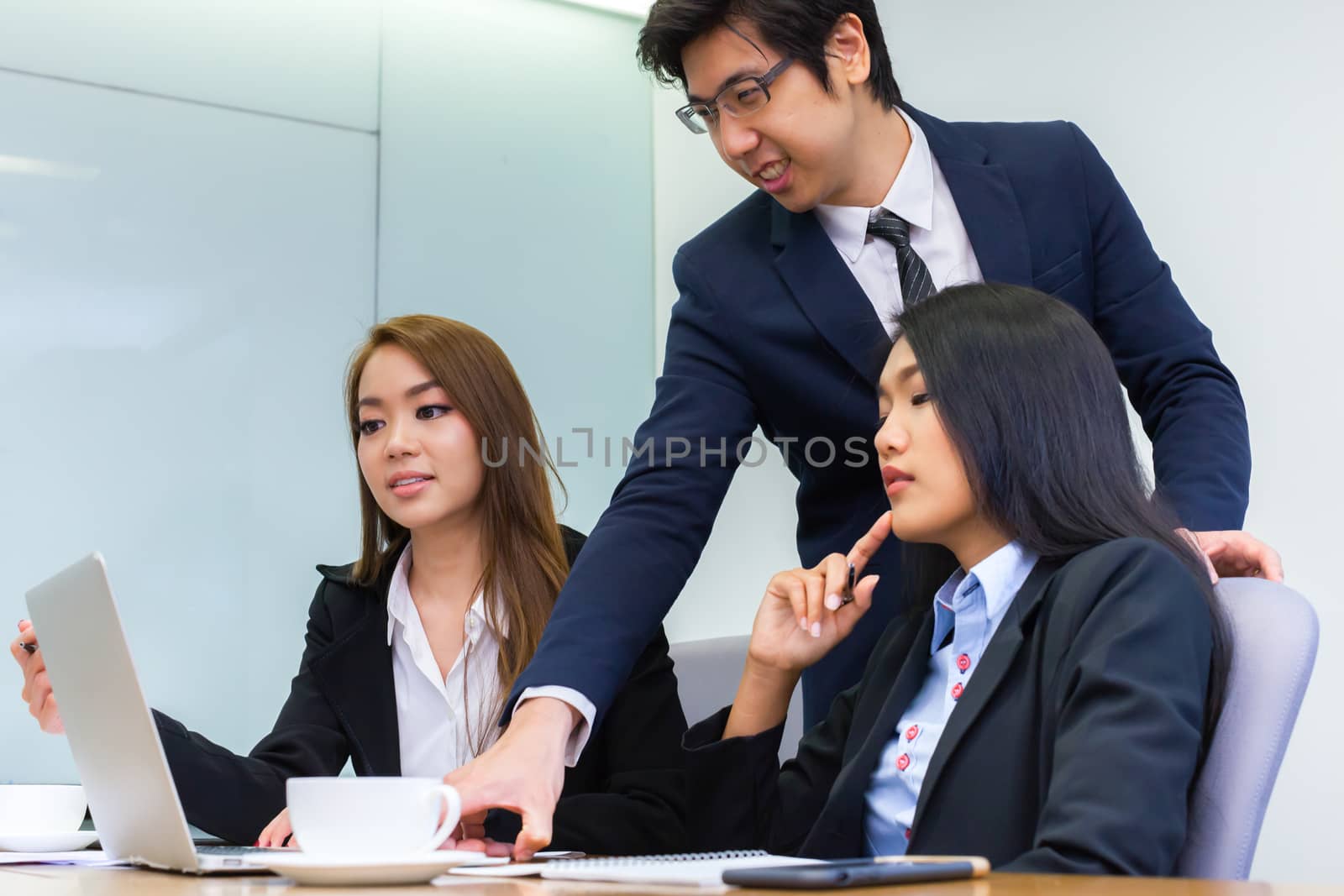 Asian business people make a group discussion in meeting room with document and computer putting on wooden table