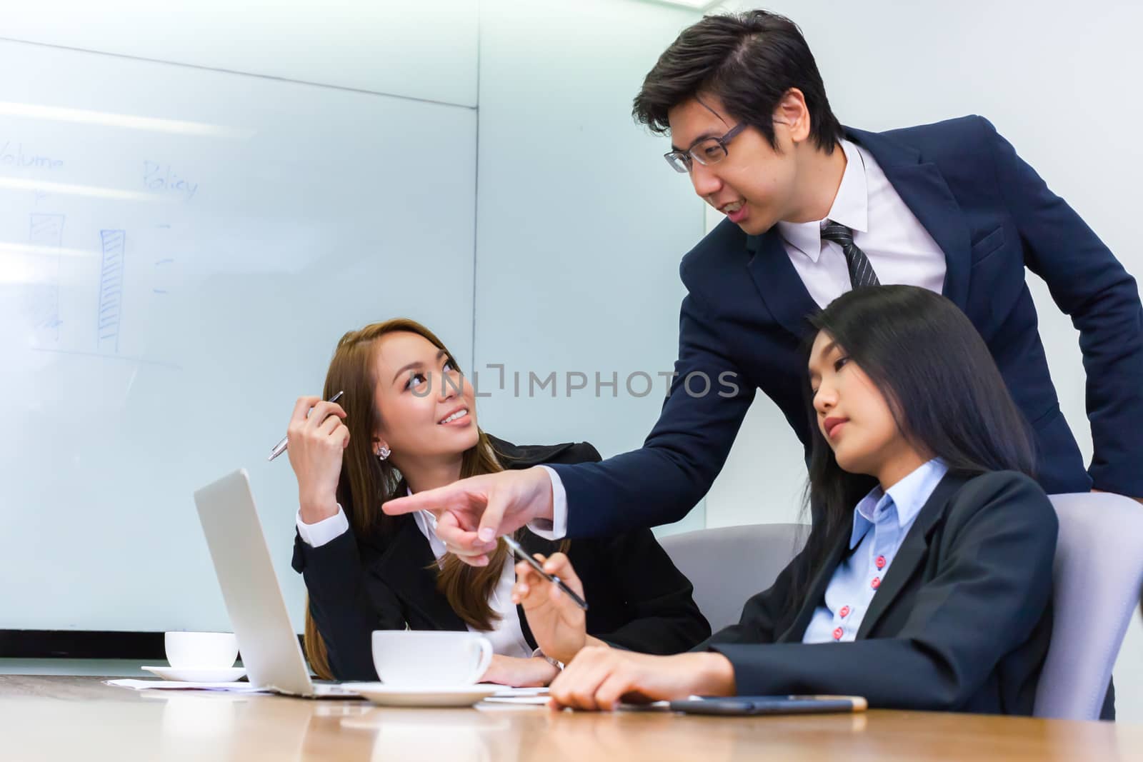 Asian business people make a group discussion in meeting room with document and computer putting on wooden table