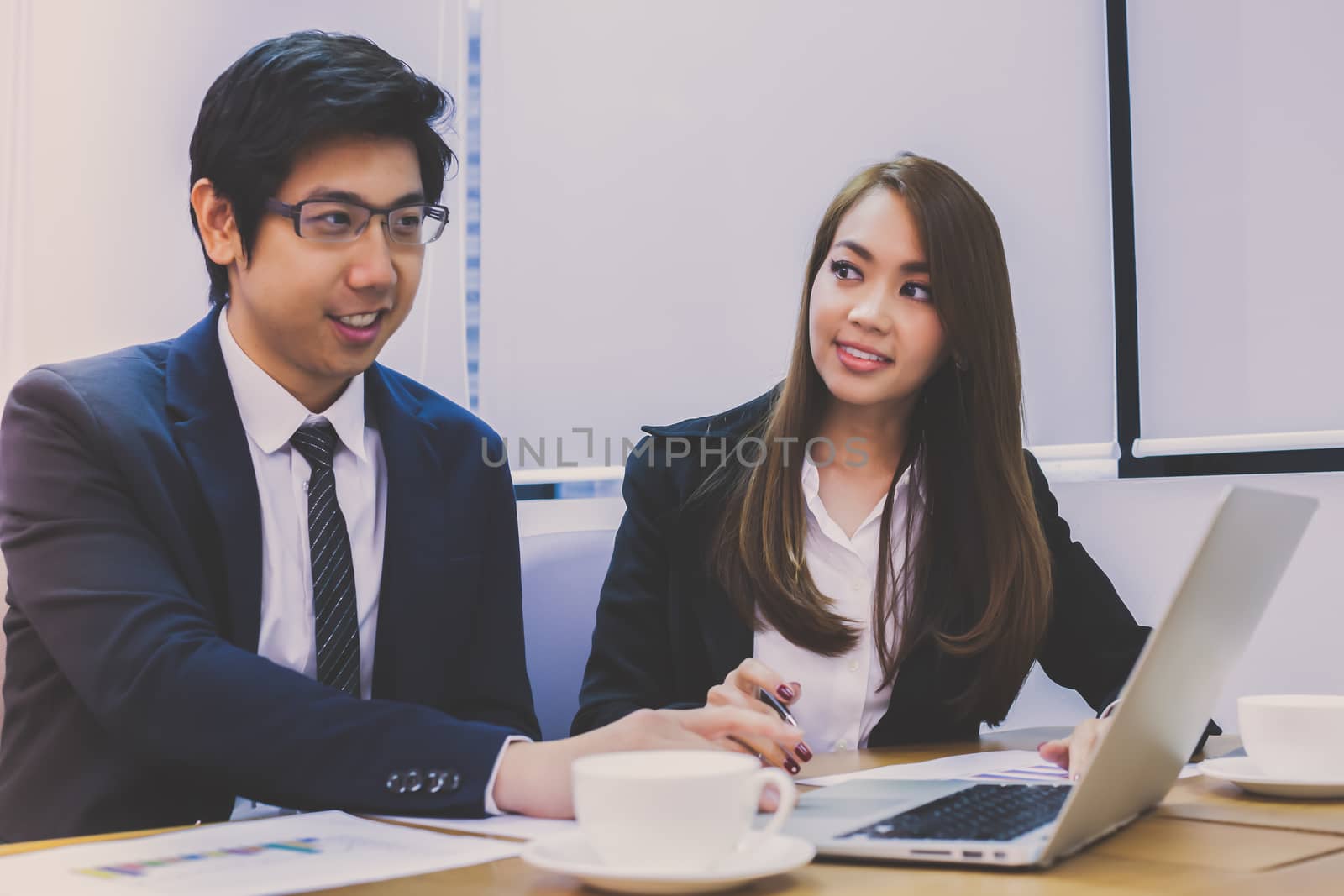 Asian business people make a group discussion in meeting room with document and computer putting on wooden table