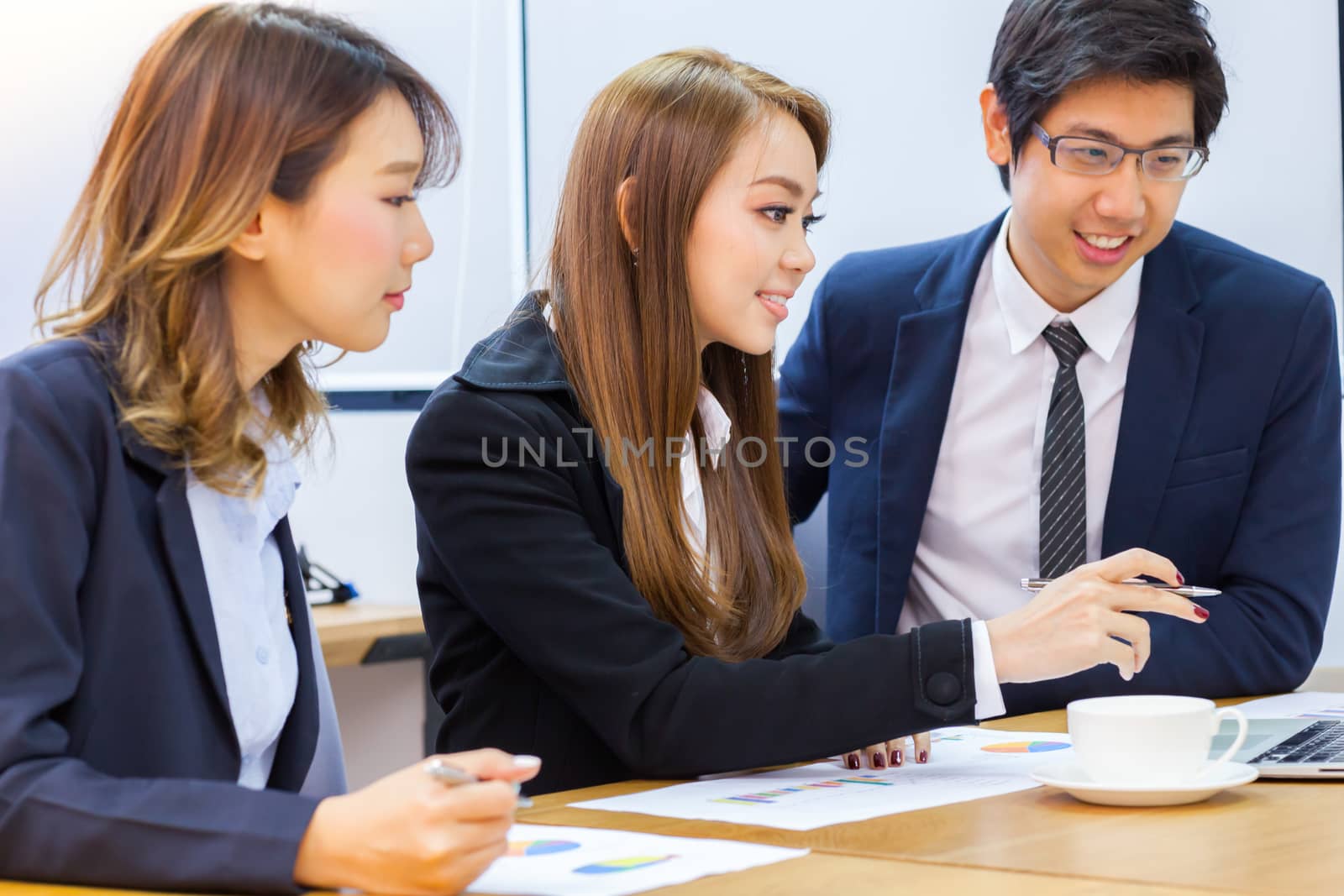 Asian business people make a group discussion in meeting room with document and computer putting on wooden table