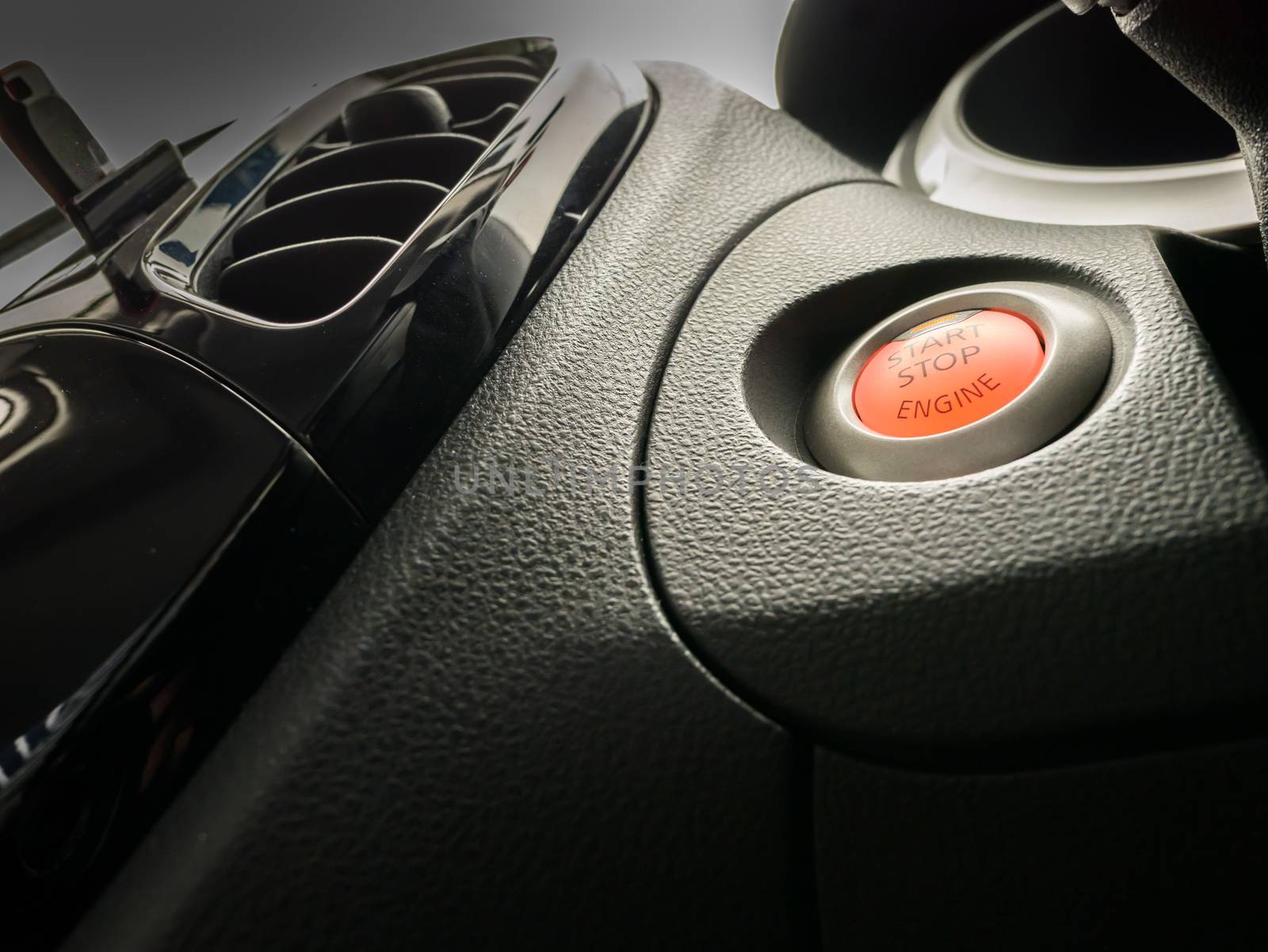 Orange color of push  button start of engine located in black dash panel