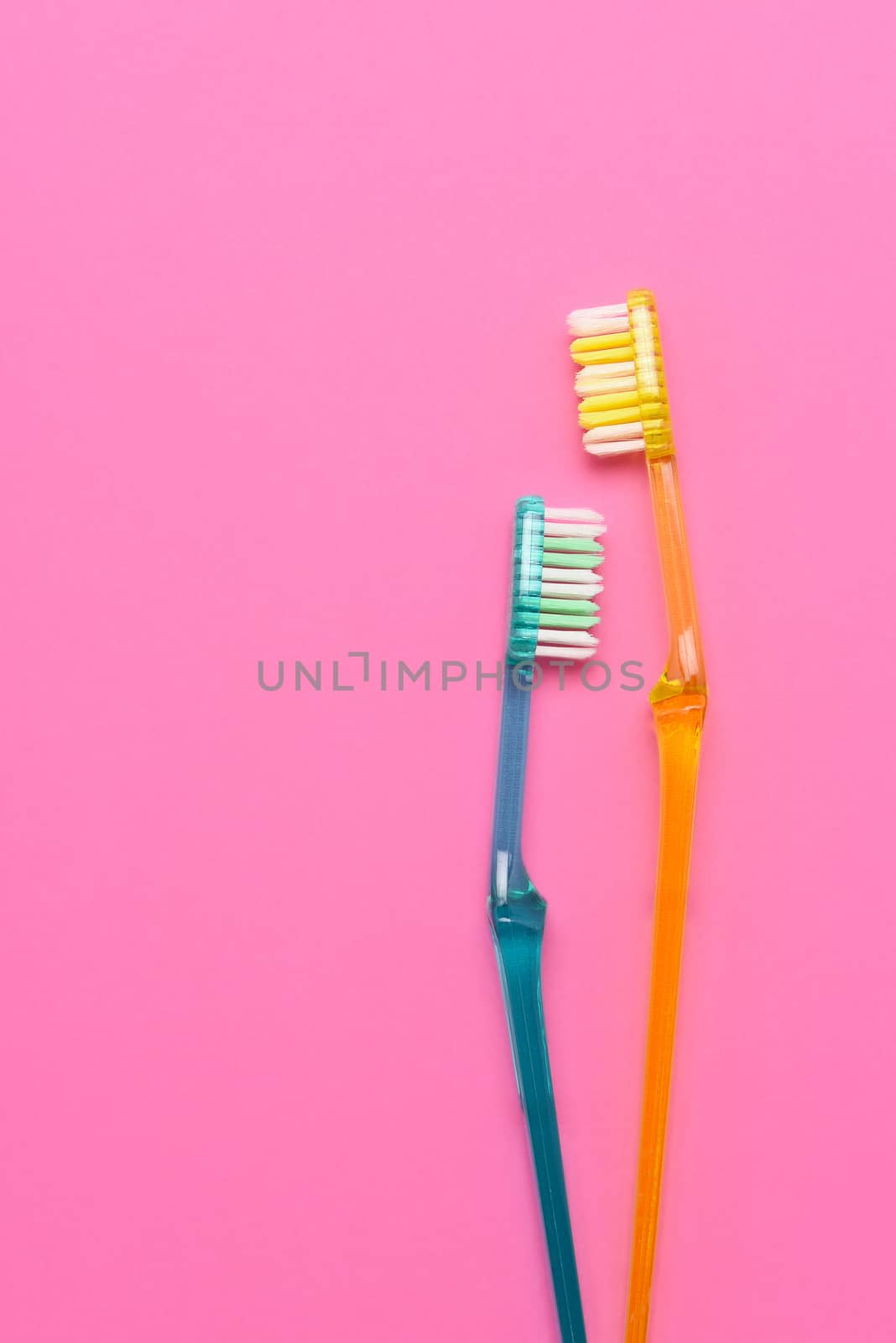 Two toothbrushes on a pink background by sCukrov