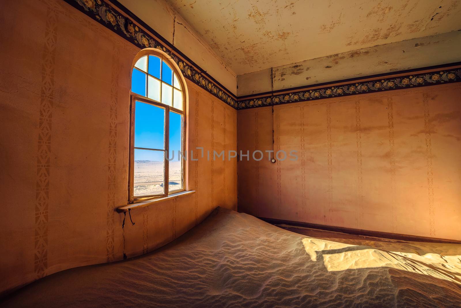 Empty room with a window and sand in the ruined ghost town Kolmanskop, Namibia by nickfox