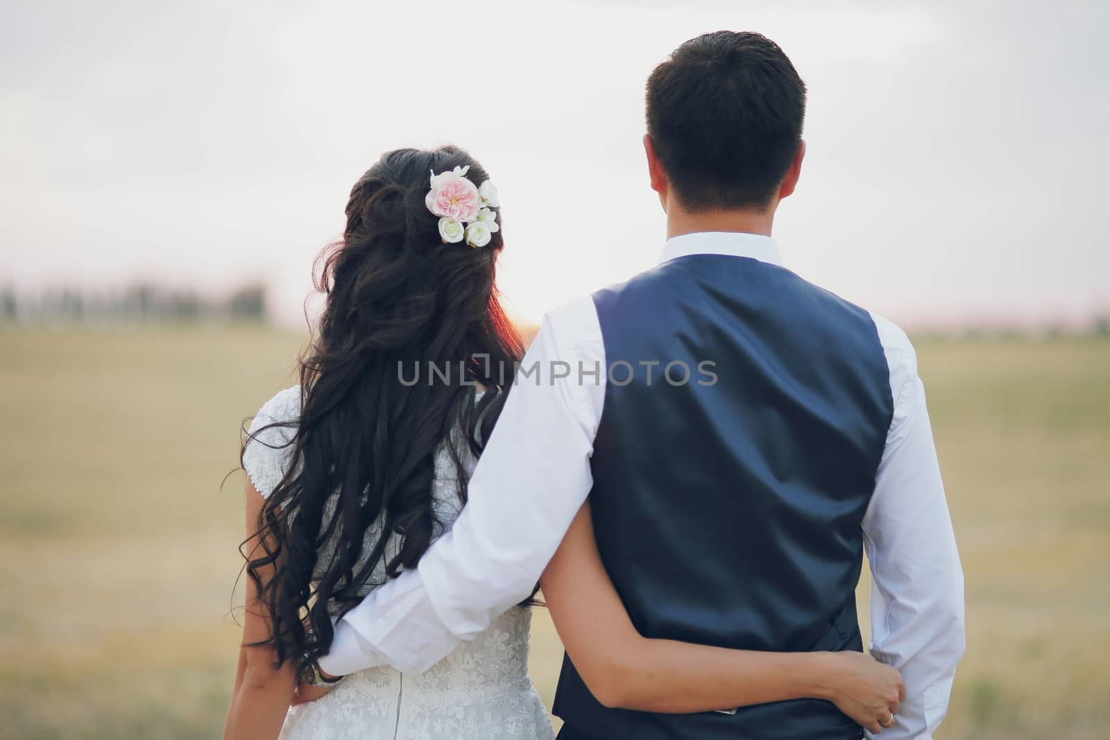 Bride and groom hold hands and meet the sunset. Wedding by selinsmo