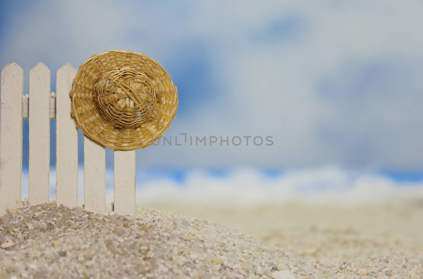 Straw Hat on fence near tropical beach