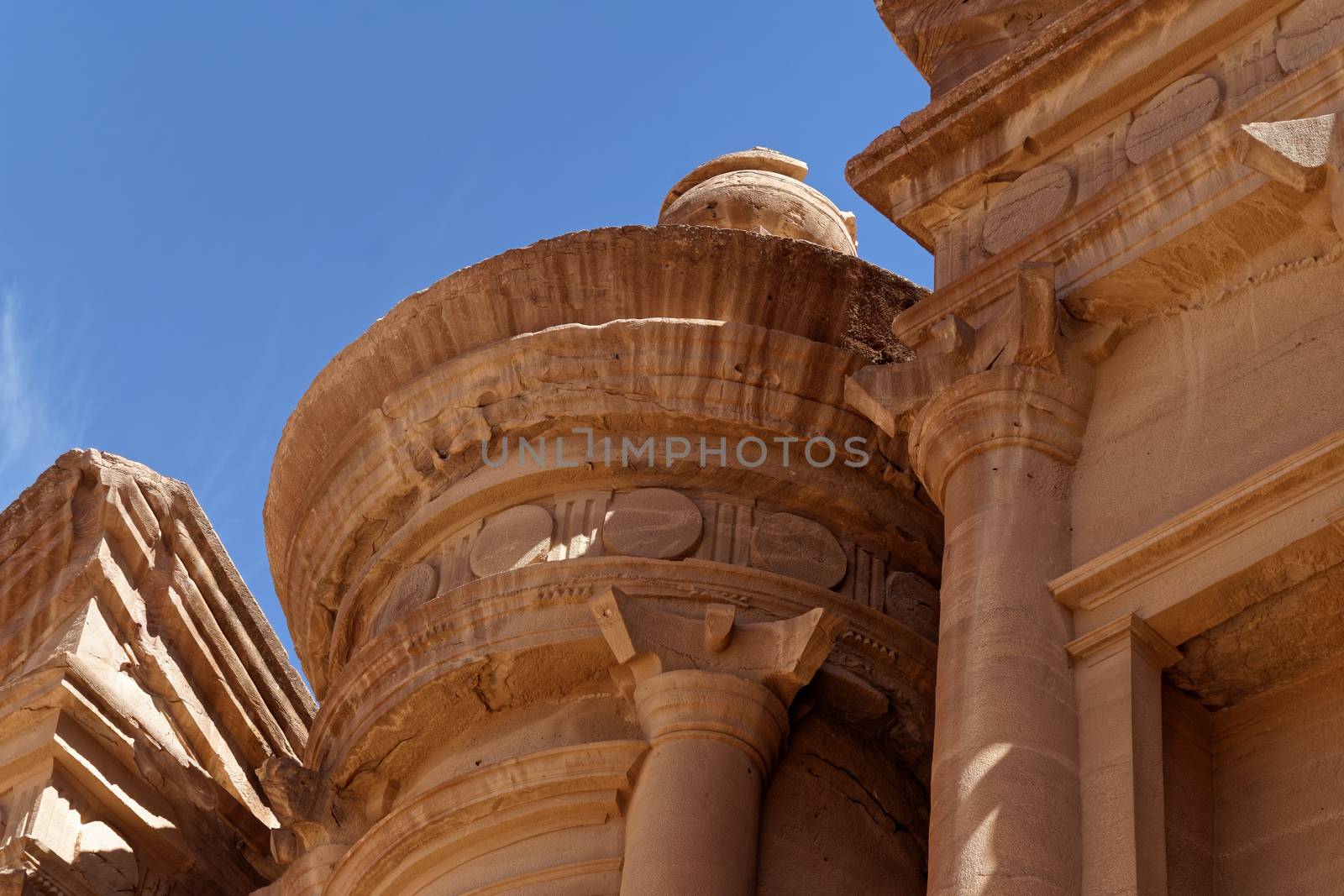 Photo taken at an oblique angle of a section of Al-Deir, the so-called monastery, in the necropolis of Petra, Jordan