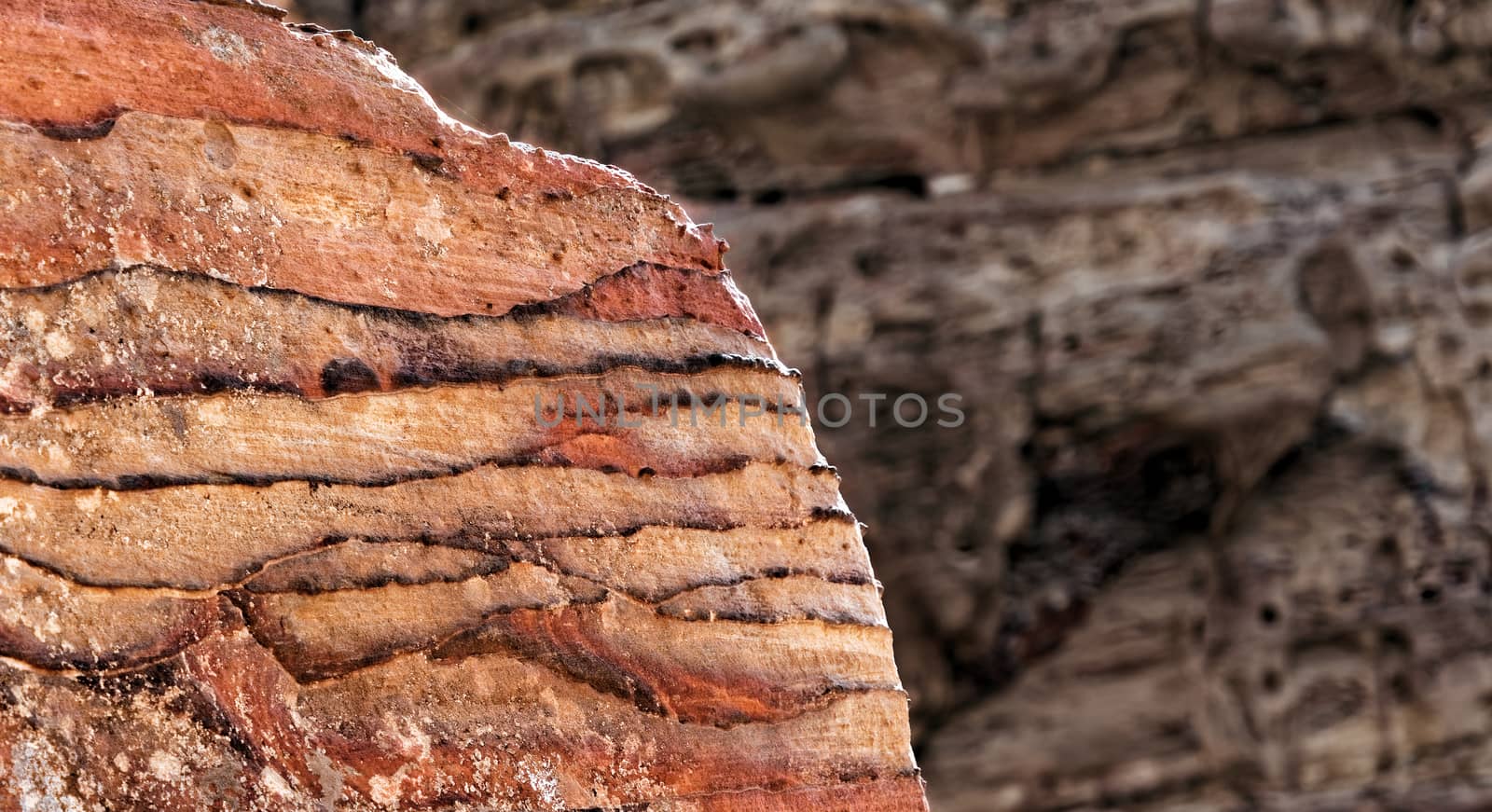 Sandstone coloured red, orange and black by iron and manganese compounds in the World Heritage of Petra, Jordan