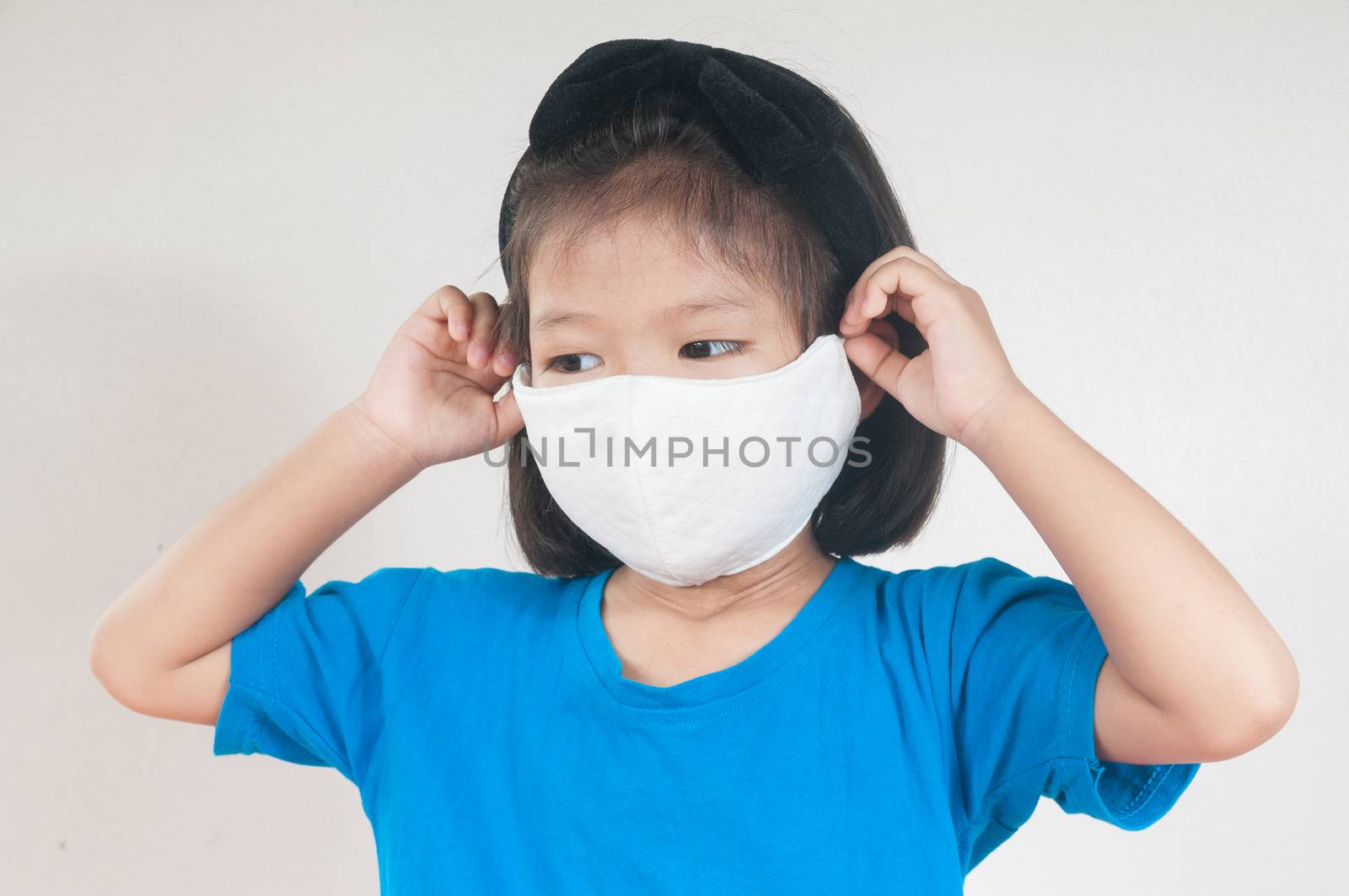 Asian child Girl or kids in blue Shirt wearing cloth mask to pro by thampapon