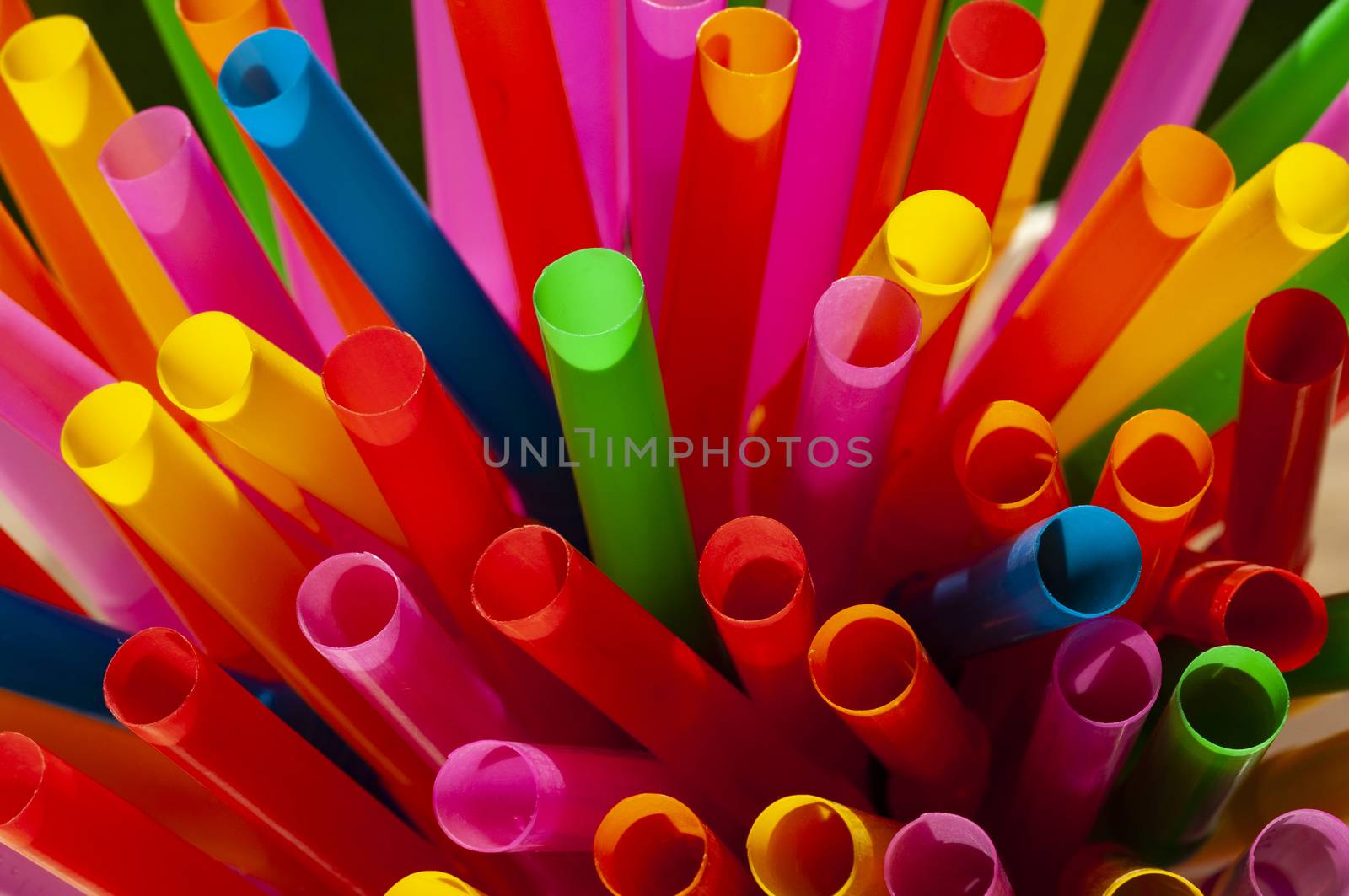 Colorful straws macro view in sunlight at the beach bar