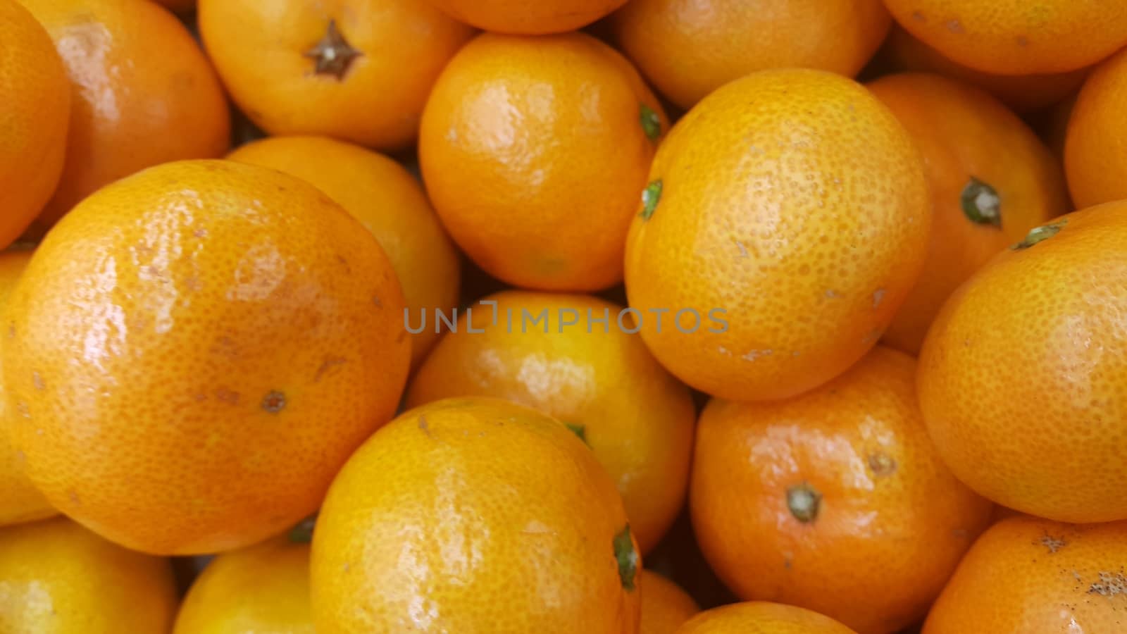 Fresh oranges in supermarket for sale, pile of orange in market for texture by Photochowk