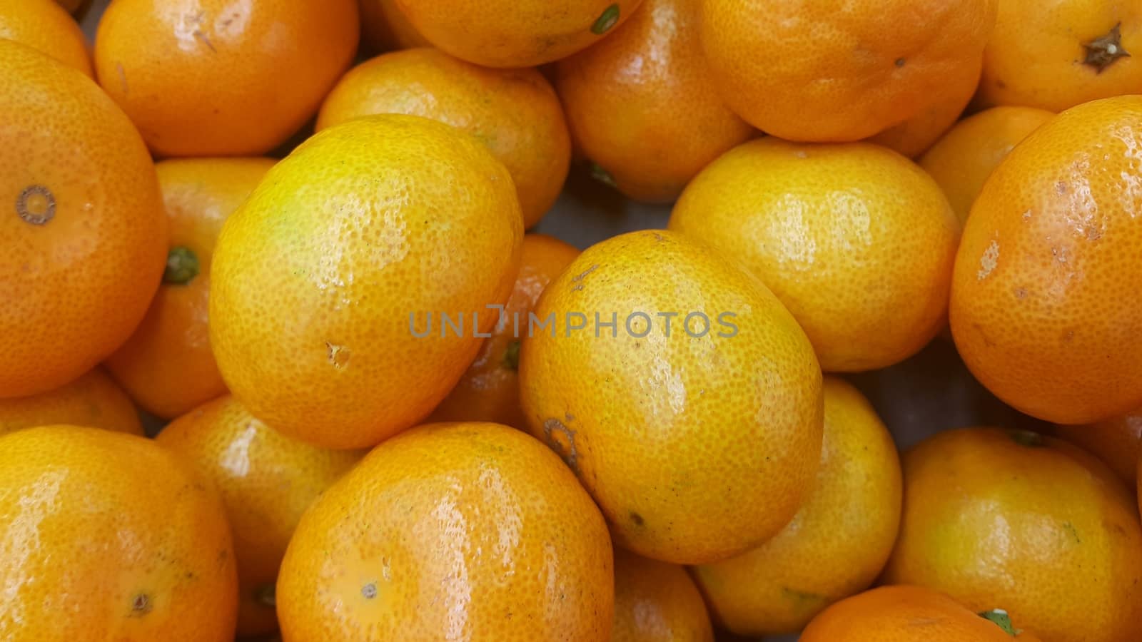 Fresh oranges in supermarket for sale, pile of orange in market for texture by Photochowk